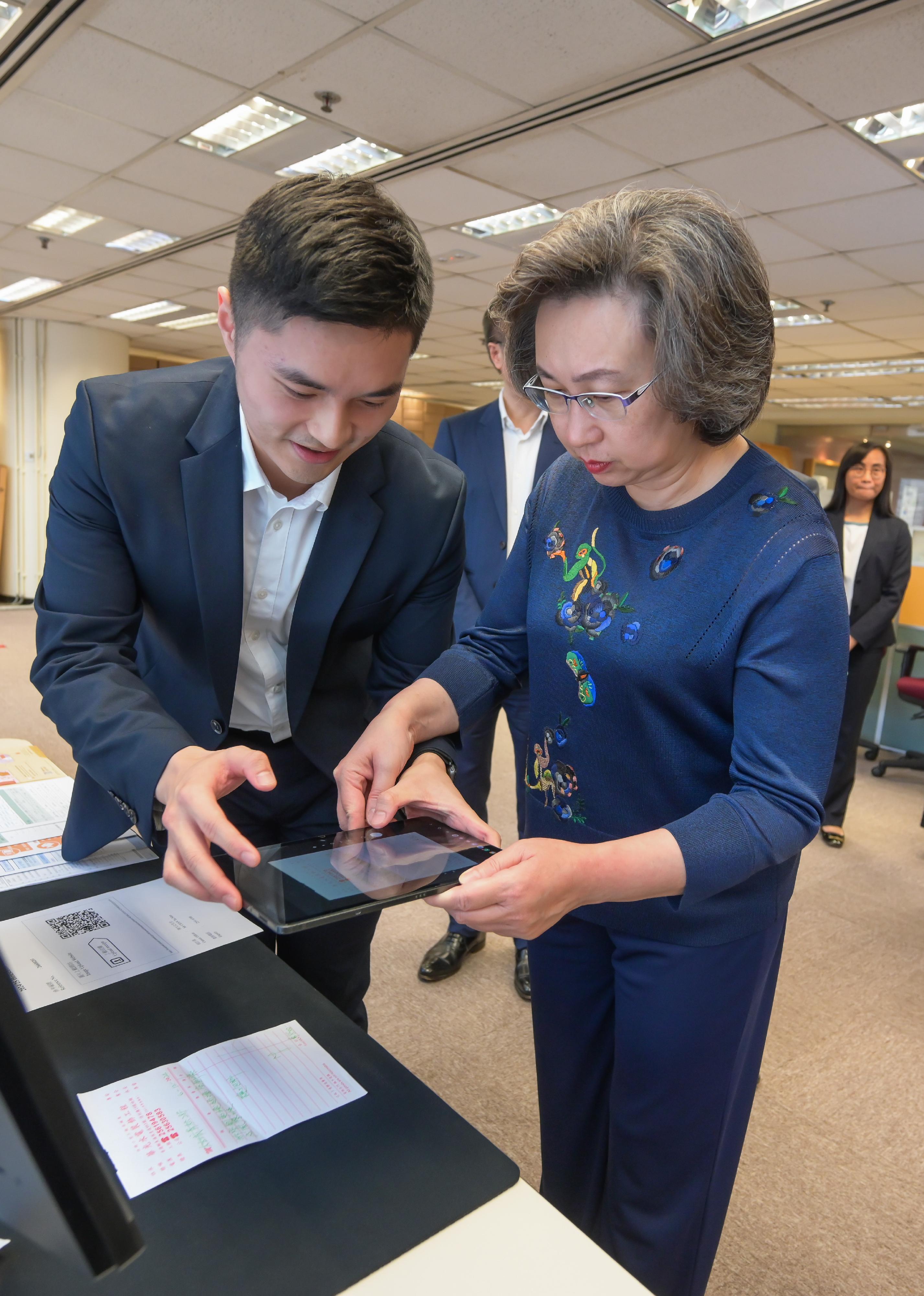 The Secretary for the Civil Service, Mrs Ingrid Yeung, visited the Census and Statistics Department (C&SD) this afternoon (May 2). Photo shows Mrs Yeung (right) being brief by staff on the C&SD's application of the Visual Language Model for receipt information recognition, thus reducing the need for manual input of different kinds of data on receipts.