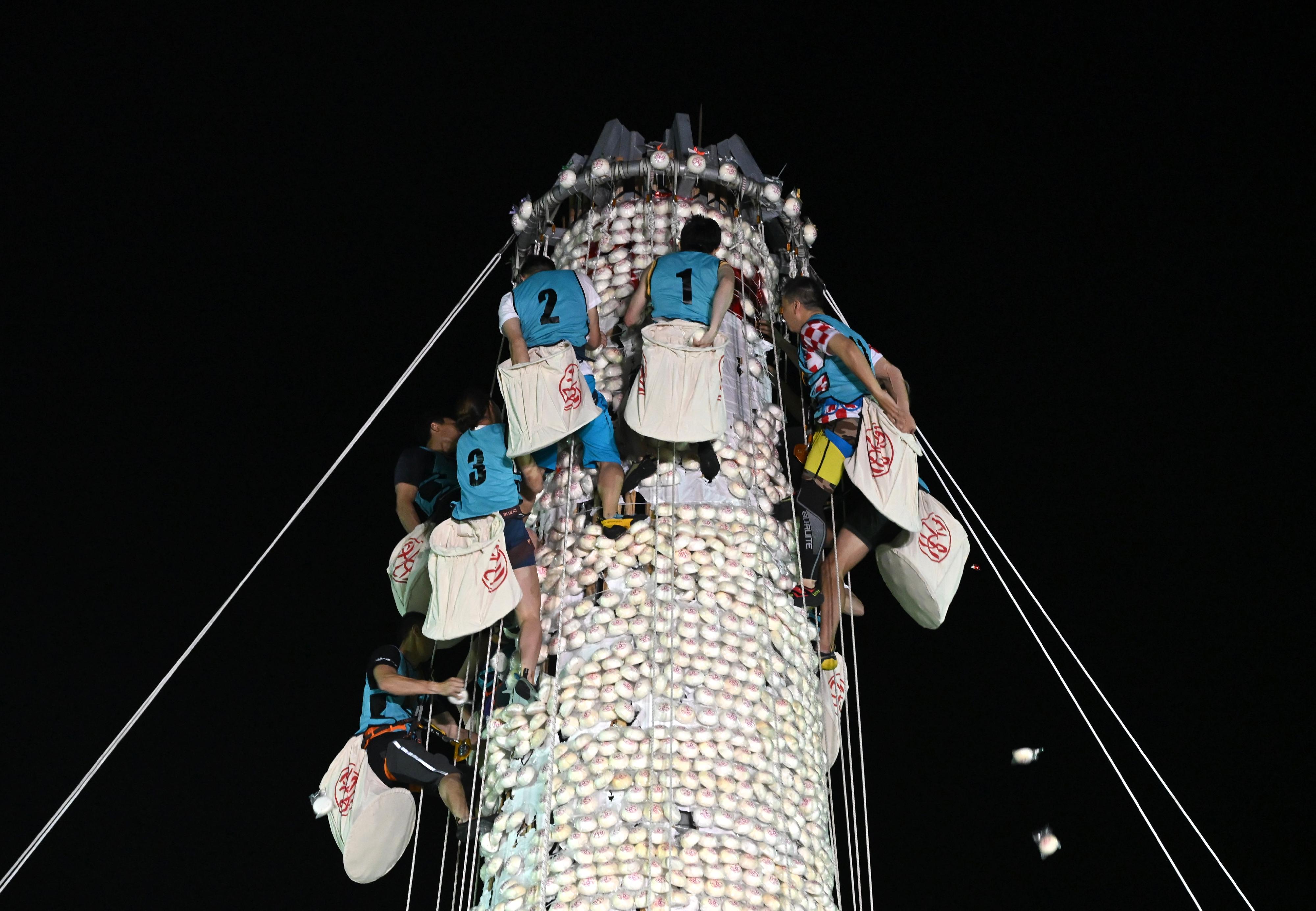 The Bun Scrambling Competition in Cheung Chau concluded early this morning (May 6). Photo shows the finalists scrambling up the bun tower to snatch as many buns as they can within a three-minute time limit to vie for the championships.



