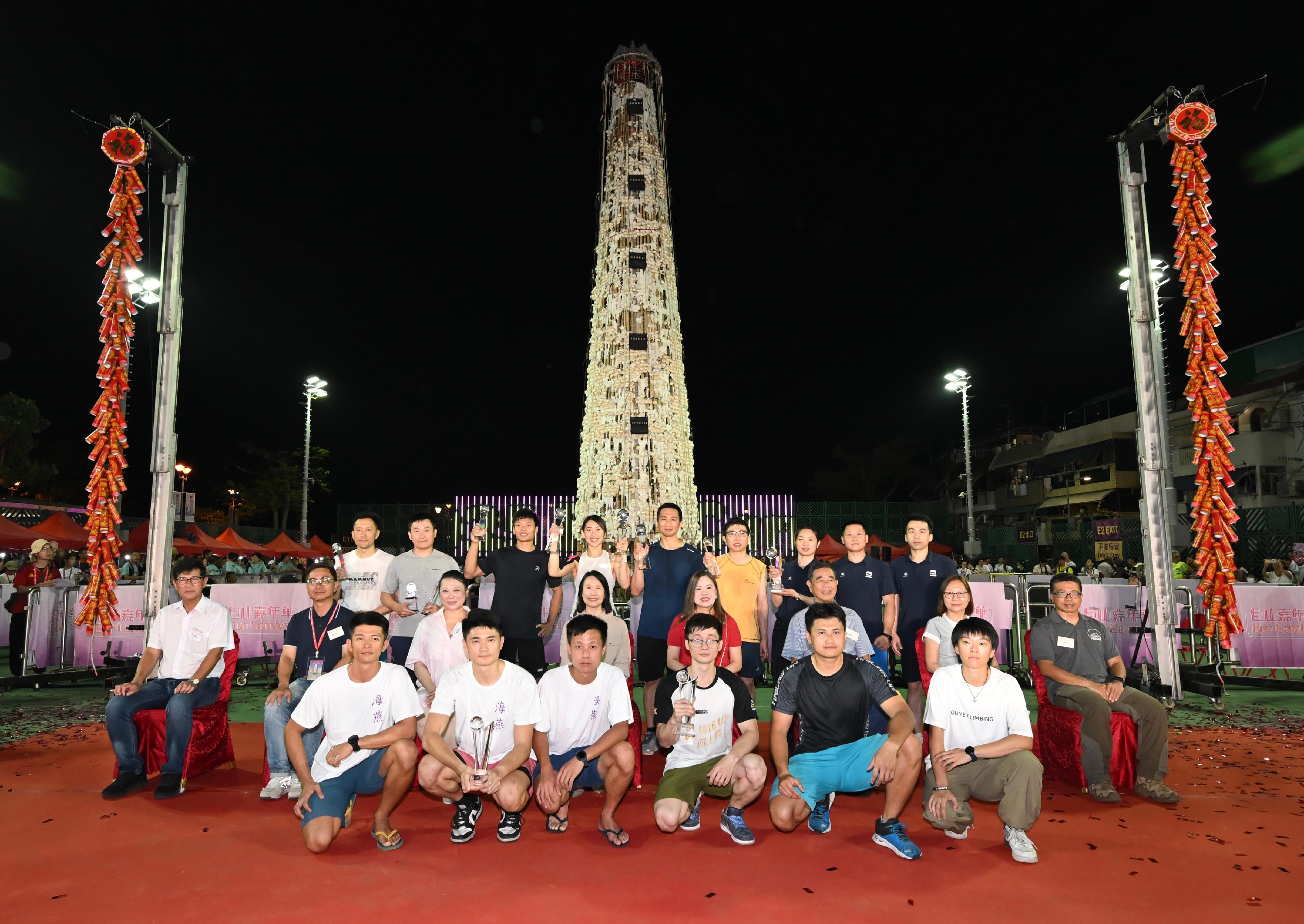 The Bun Scrambling Competition in Cheung Chau concluded early this morning (May 6). The Secretary for Culture, Sports and Tourism, Miss Rosanna Law (second row, fourth right); the Director of Leisure and Cultural Services, Ms Manda Chan (second row, fourth left); the Chairman of the Hong Kong Cheung Chau Bun Festival Committee, Mr Yung Chi-ming (second row, third right); the Chairman of the Islands District Council, Ms Amy Yeung (second row, third left); and other officiating guests are pictured with the winners.
