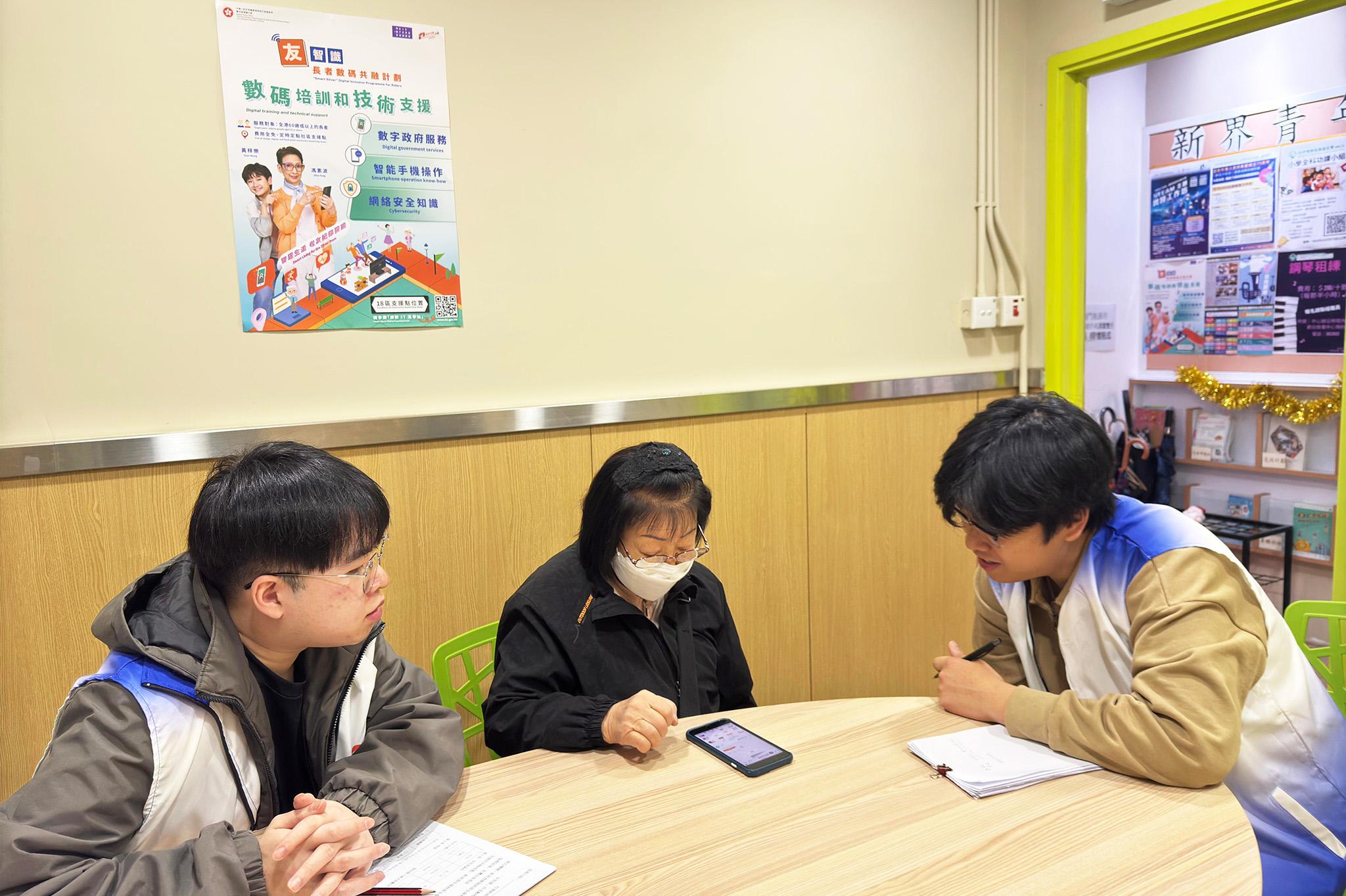 「友智識」長者數碼共融計劃獲得長者踴躍參與。圖示推行機構在社區支援點提供服務，解答長者在使用智能手機方面的查詢。