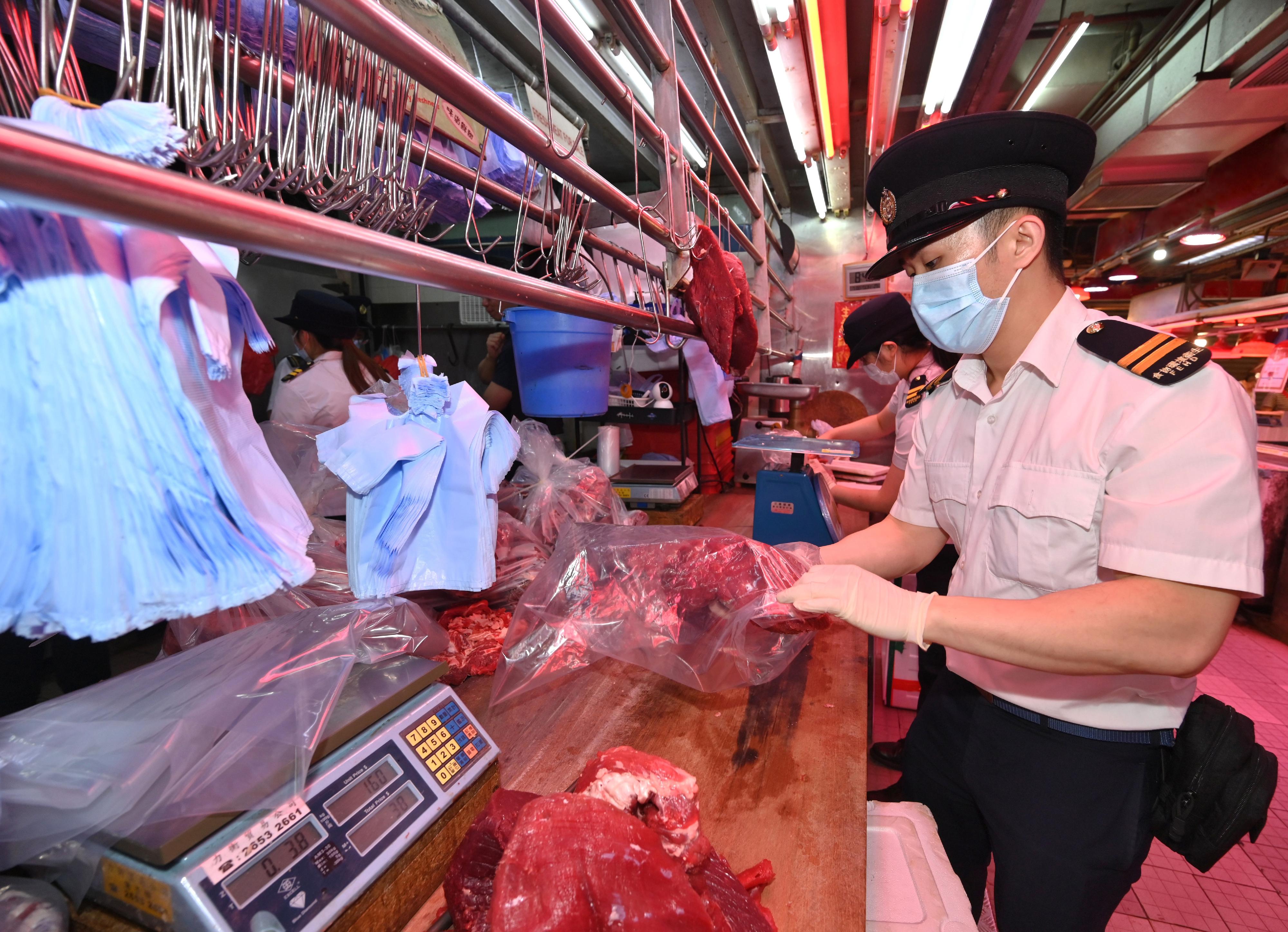 食物環境衞生署（食環署）今日（五月七日）在沙田區向一間懷疑以冷藏肉充當新鮮肉出售的持牌新鮮糧食店採取執法行動。圖示食環署人員在行動中封存部分肉類作進一步調查。