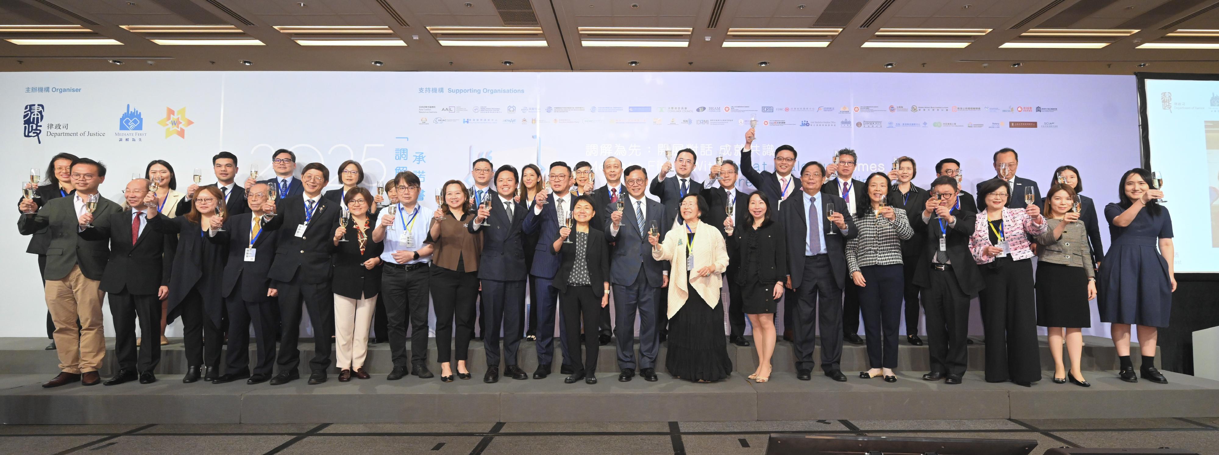 The biennial "Mediate First" Pledge Event organised by the Department of Justice (DoJ) was held today (May 9). Photo shows the Deputy Secretary for Justice, Dr Cheung Kwok-kwan (front row, ninth right), the Law Officer (Civil Law) of the DoJ, Ms Christina Cheung (front row, tenth right), and representatives of supporting organisations proposing a toast.