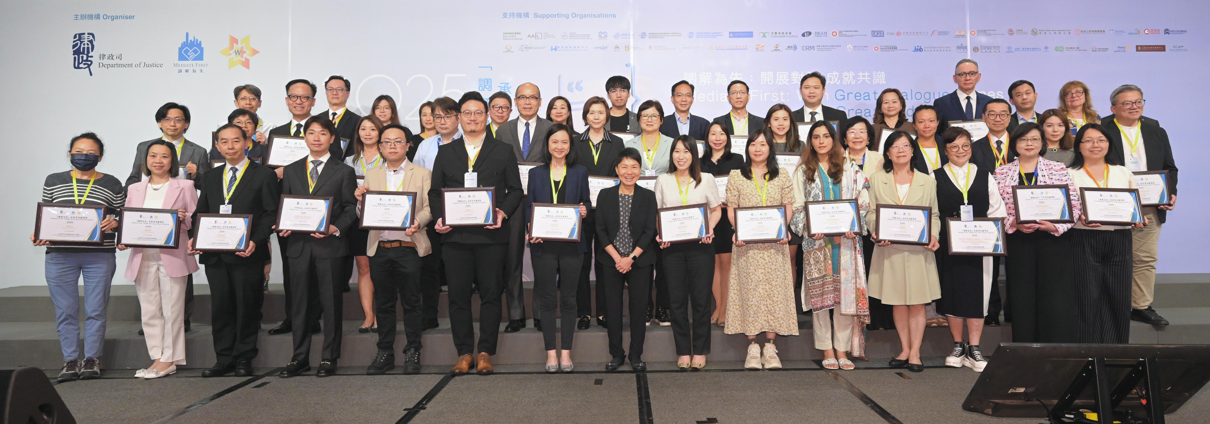 The biennial "Mediate First" Pledge Event organised by the Department of Justice (DoJ) was held today (May 9). Photo shows the Law Officer (Civil Law) of the DoJ, Ms Christina Cheung (first row, centre), presenting awards at the Star Logo Award Presentation Ceremony.