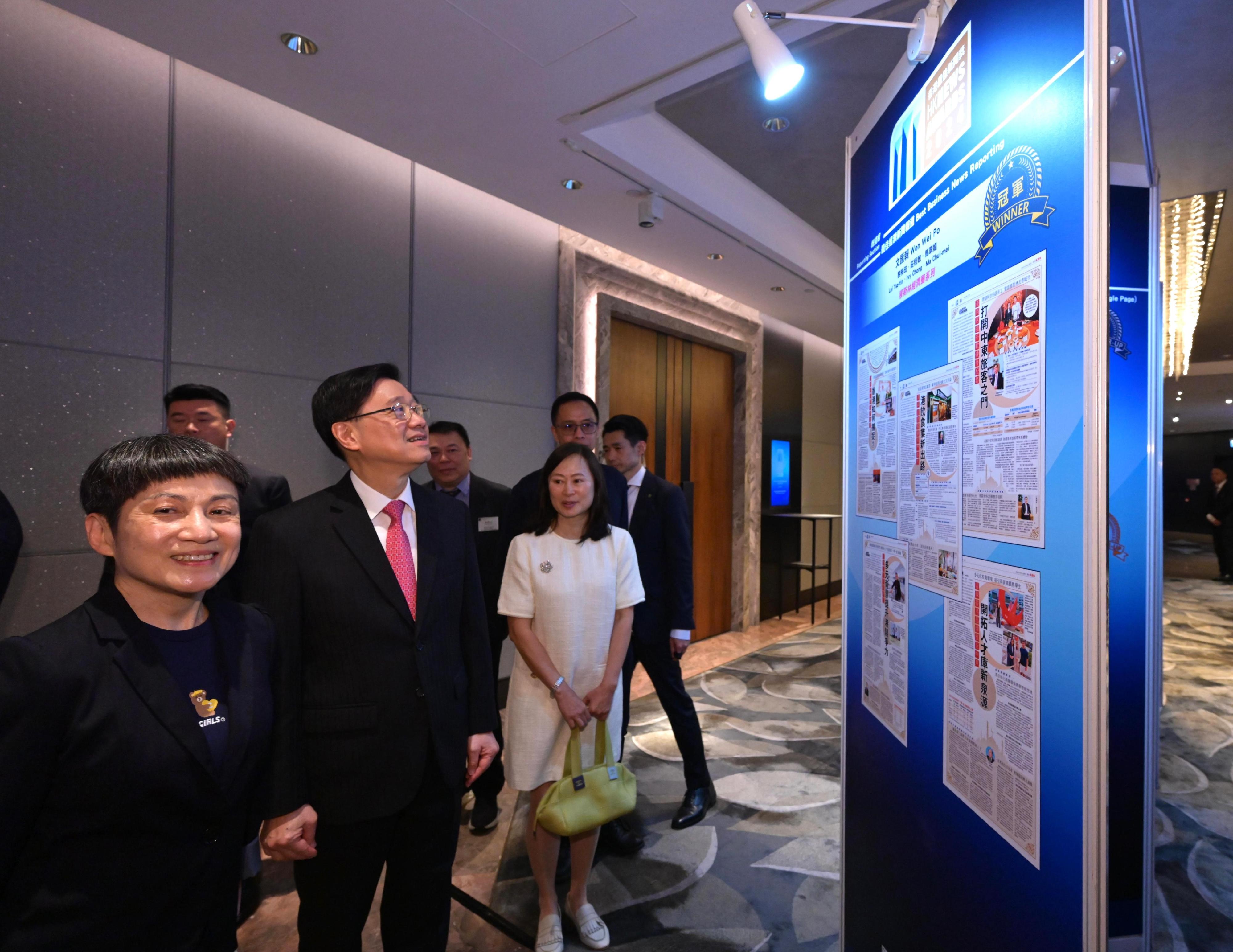 行政長官李家超今日（五月九日）出席2024香港最佳新聞獎頒獎典禮暨午餐會。圖示李家超（左二）在香港報業公會主席郭艷明（左一）陪同下參觀展板。