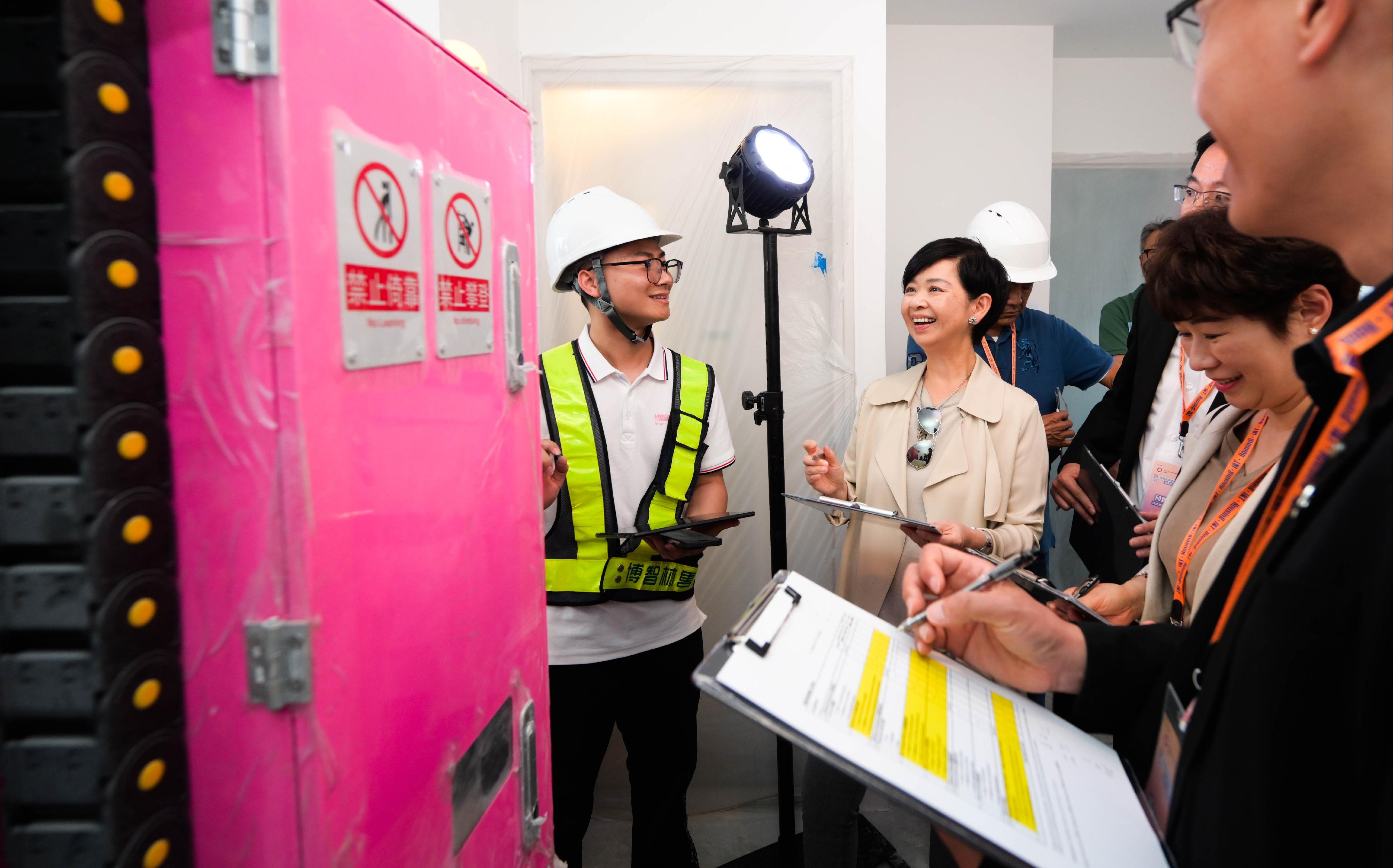 房屋局今日（五月十二日）舉辦「房屋建築機械人——油漆大師比拼賽x武林大會」，以促進行業技術落地，帶領公營房屋發展邁入智能建造新紀元。圖示房屋局局長何永賢（左二）與評審團為油漆大師比拼賽進行評審。
