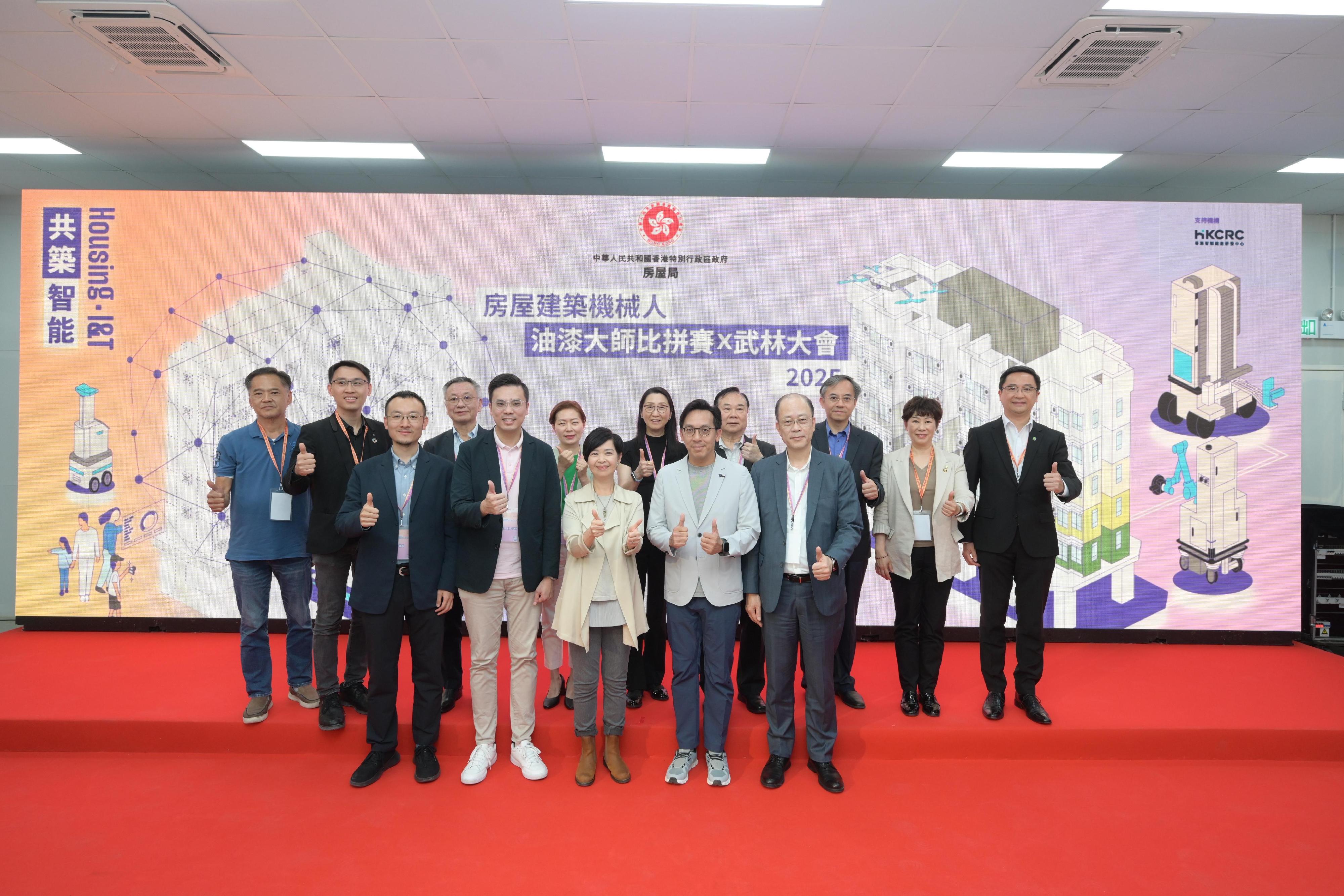 The Housing Bureau organised the Construction Robots for Housing - RoboPaint Master Competition x Arena of Construction Robots today (May 12) to promote the adoption of industry technologies and advance public housing developments into a new era of smart construction. Photo shows the Secretary for Housing, Ms Winnie Ho (front row, centre), the Deputy Director (Development and Construction) of the Housing Department, Mr Daniel Leung (front row, second right), and other guests.
