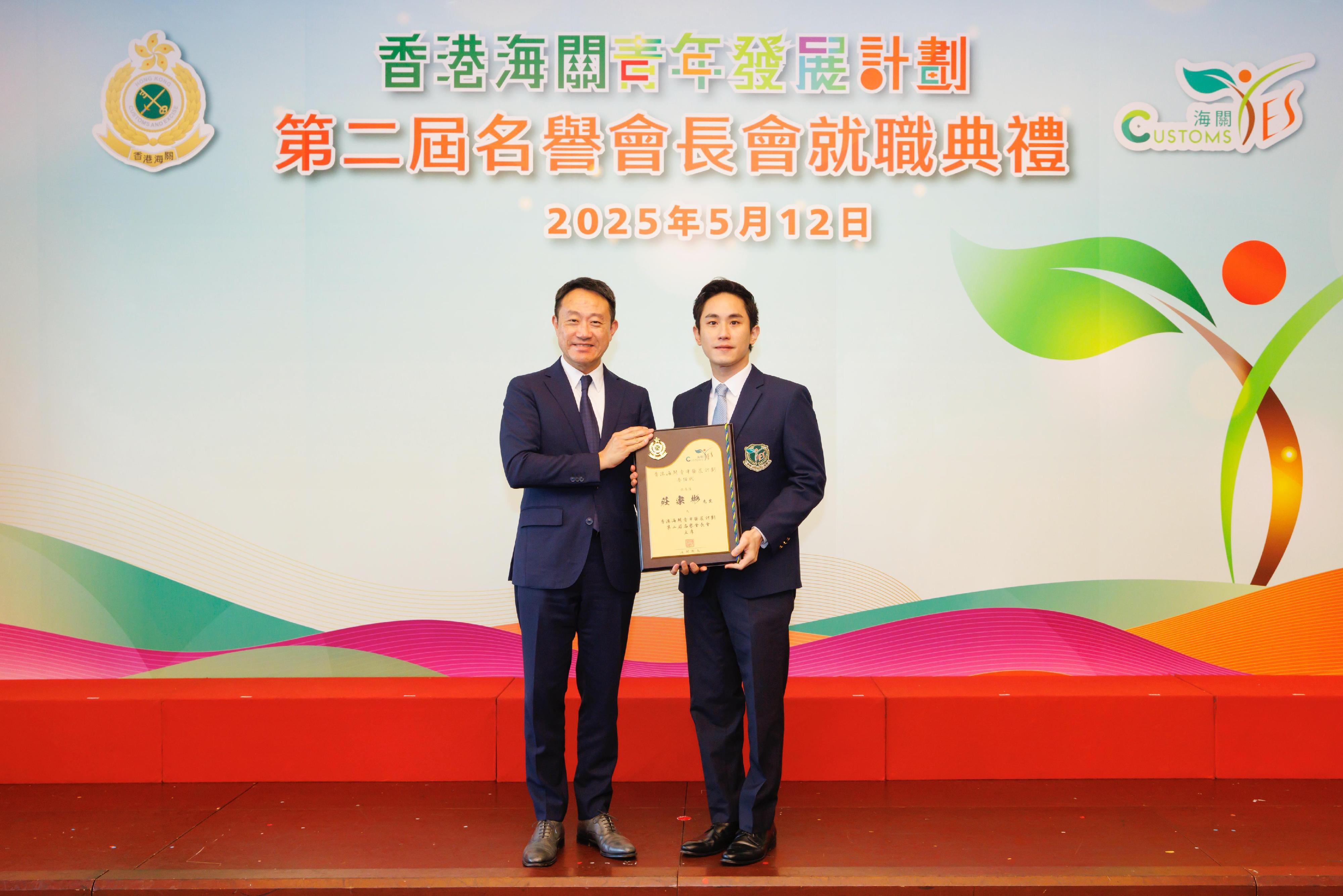 香港海關今日（五月十二日）在香港海關總部大樓舉行「香港海關青年發展計劃」第二屆名譽會長會就職典禮。圖示海關關長陳子達（左）頒發委任狀予新任主席莊家彬（右）。
