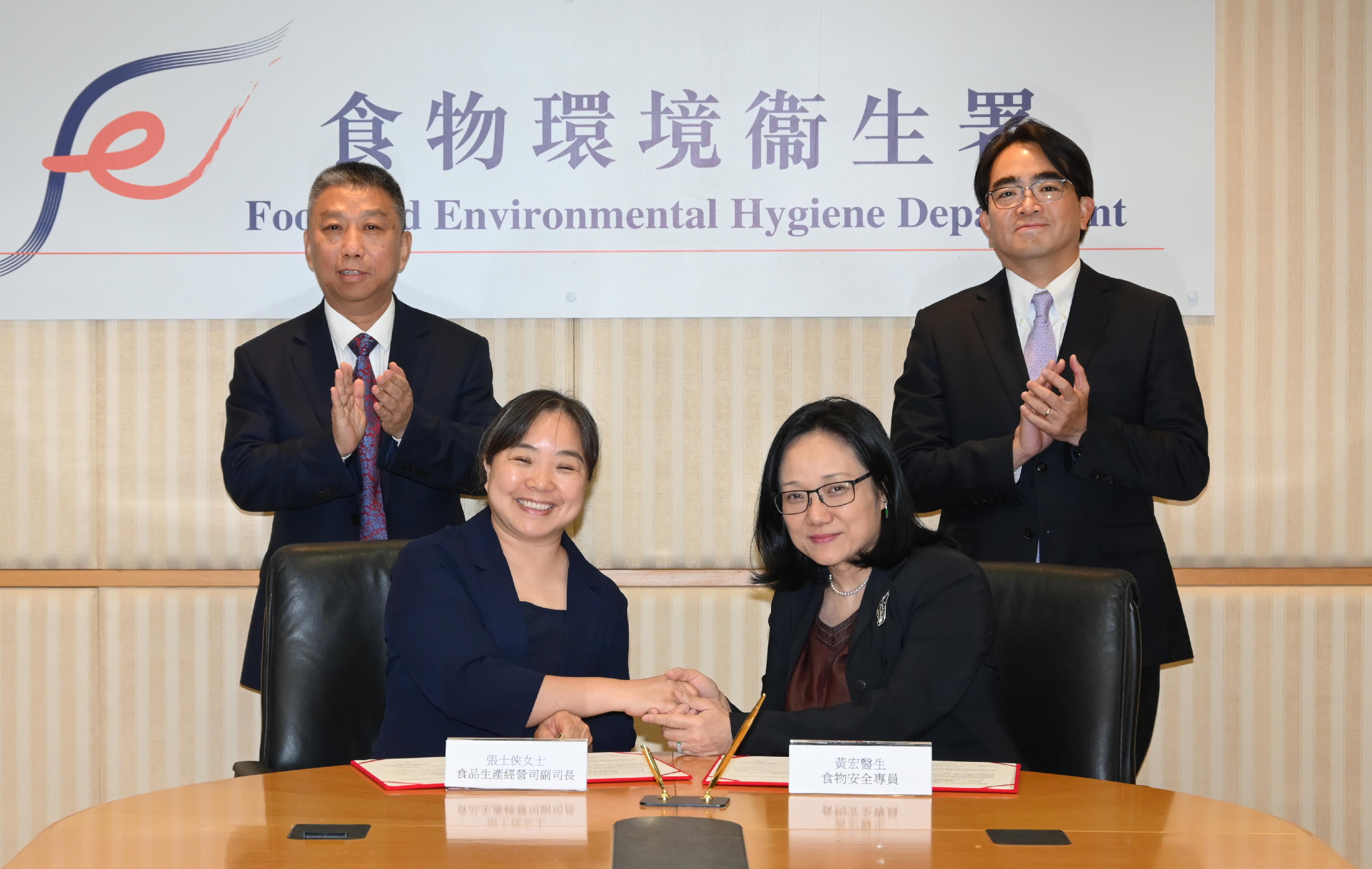 The Centre for Food Safety (CFS) of the Food and Environmental Hygiene Department of the Government of the Hong Kong Special Administrative Region and the Department of Food Safety Sampling and Monitoring of the State Administration for Market Regulation (SAMR) signed a Memorandum of Understanding (MOU) on food safety co-operation today (May 12). Picture shows the Director of Food and Environmental Hygiene, Mr Donald Ng (back row, right), and the Chief Inspector of Food Safety of the SAMR, Mr Sun Huichuan (back row, left), witnessing the signing of the MOU by the Controller of the CFS, Dr Christine Wong (front row, right), and the Deputy Director General of the Department of Food Production and Operation Safety Regulation of the SAMR, Ms Zhang Shixia (front row, left).
