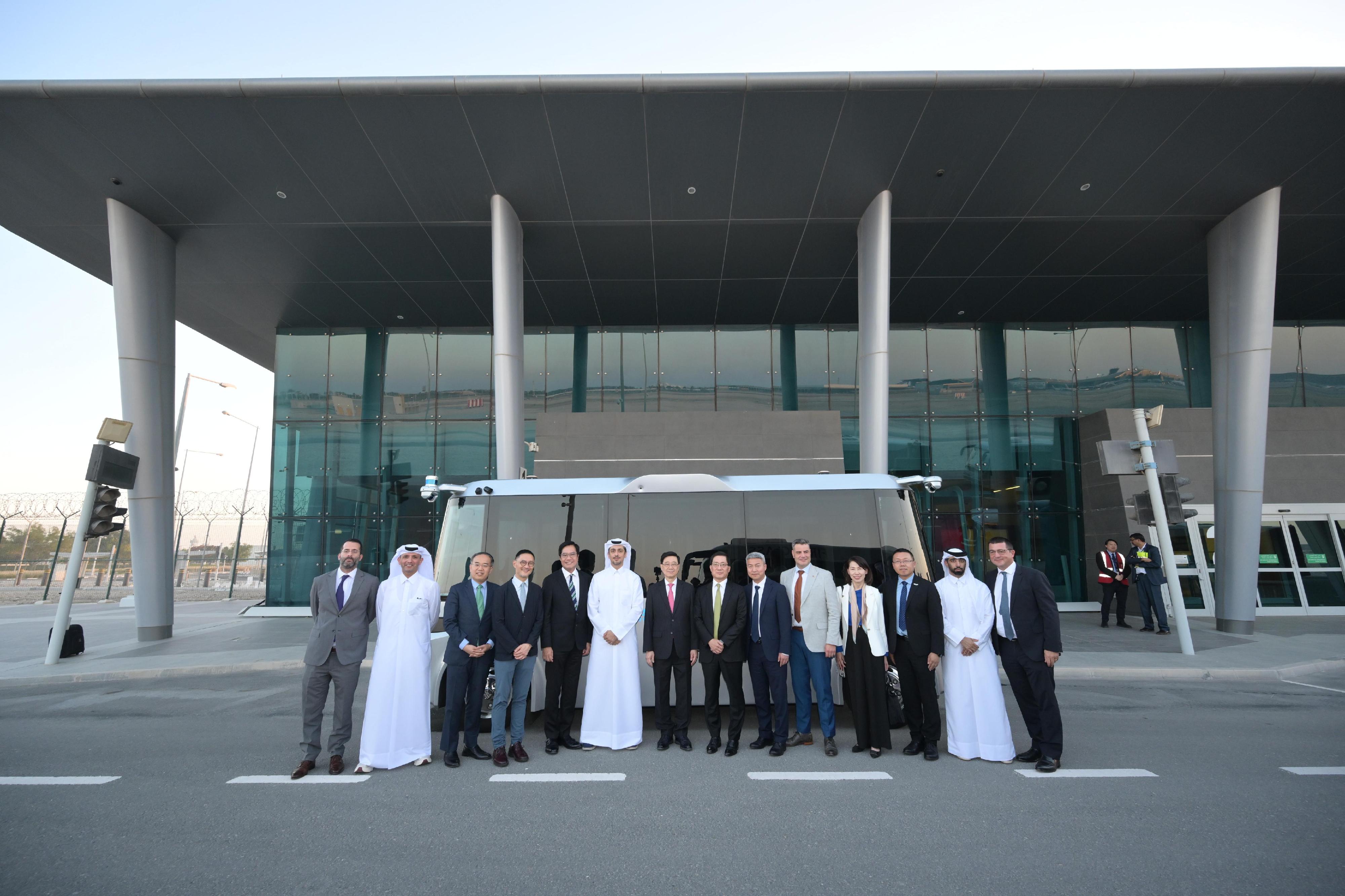 The Chief Executive, Mr John Lee, today (May 12) learned about the operation and effectiveness of the autonomous vehicle system pilot scheme in Hamad International Airport in Doha, Qatar. Photo shows Mr Lee (seventh left) being briefed on the operation of the vehicles of UISEE, a Mainland Chinese company with its international headquarters in Hong Kong participating in the pilot scheme.