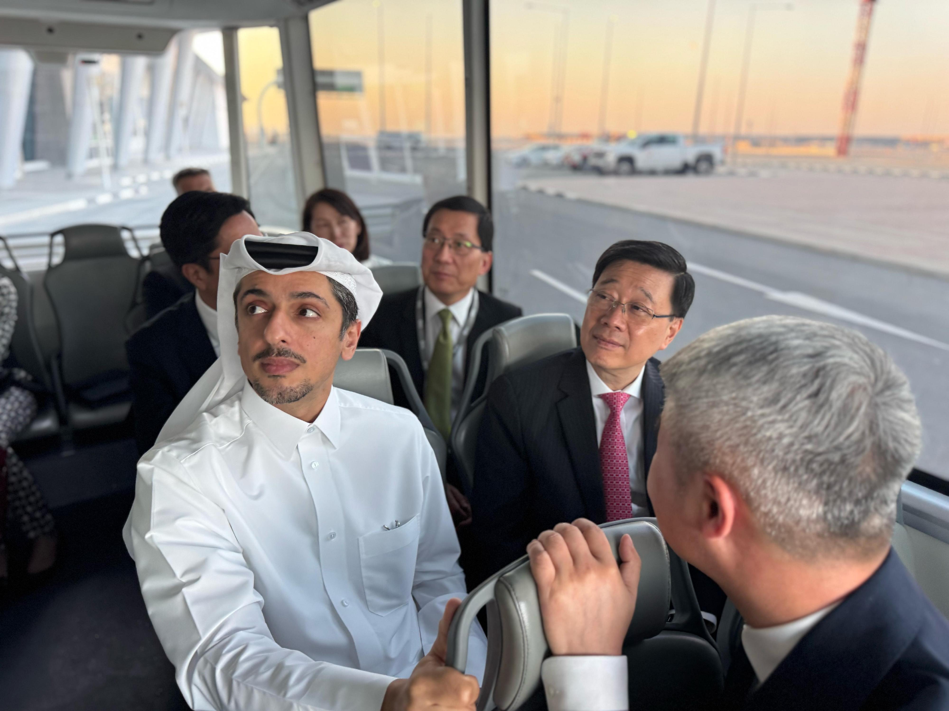 The Chief Executive, Mr John Lee, today (May 12) learned about the operation and effectiveness of the autonomous vehicle system pilot scheme in Hamad International Airport in Doha, Qatar. Photo shows Mr Lee (front row, right) experiencing a ride on an autonomous bus.
