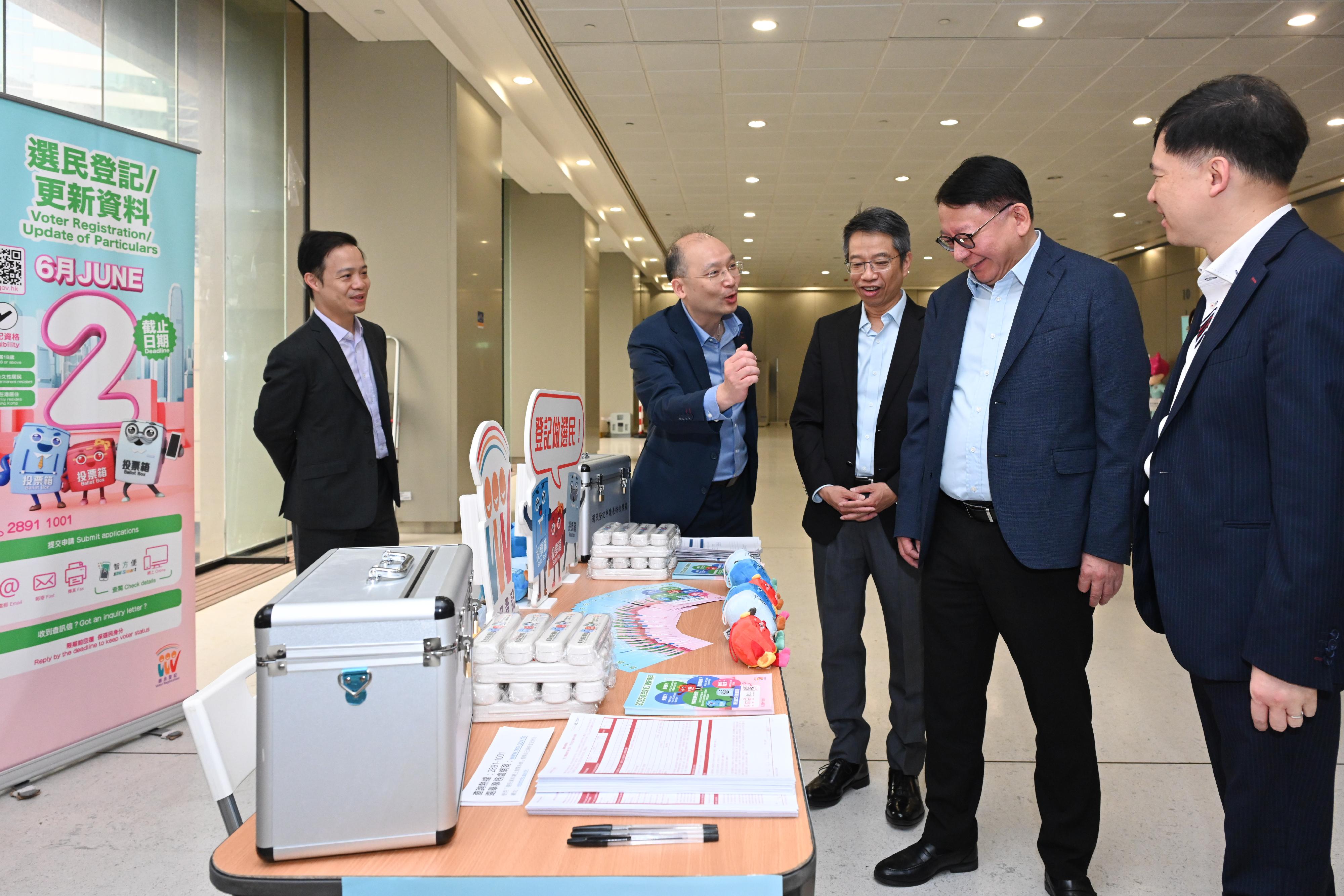 The Chief Secretary for Administration, Mr Chan Kwok-ki, together with representatives from the four civil service central consultative councils, jointly visited several floors of the Queensway Government Offices (QGO) today (May 13) to appeal to colleagues to actively register as voters and to cast their votes in the Legislative Council General Election to be held on December 7 this year to fulfil their civic responsibility. Photo shows Mr Chan (second right); the Acting Secretary for Constitutional and Mainland Affairs, Mr Clement Woo (first right); and the Permanent Secretary for the Civil Service, Mr Clement Leung (centre), visiting a mobile voter registration booth set up by the Registration and Electoral Office at the QGO. Looking on is Acting Deputy Secretary for Constitutional and Mainland Affairs Mr Niki Kwok (first left).