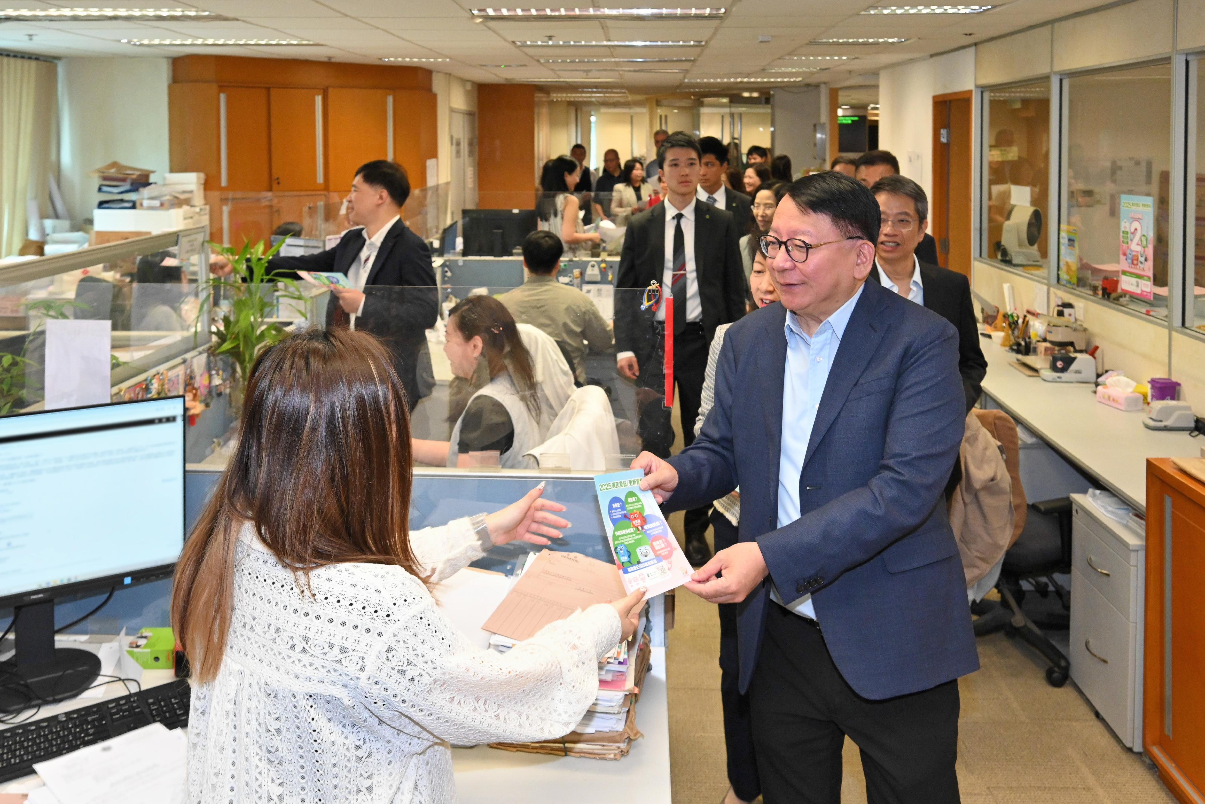 The Chief Secretary for Administration, Mr Chan Kwok-ki, together with representatives from the four civil service central consultative councils, jointly visited several floors of the Queensway Government Offices today (May 13) to appeal to colleagues to actively register as voters and to cast their votes in the Legislative Council General Election to be held on December 7 this year to fulfil their civic responsibility. Photo shows Mr Chan (right) handing out leaflets on voter registration and updates of particulars to civil service colleagues from the Land Registry at their workplace to convey the message. 