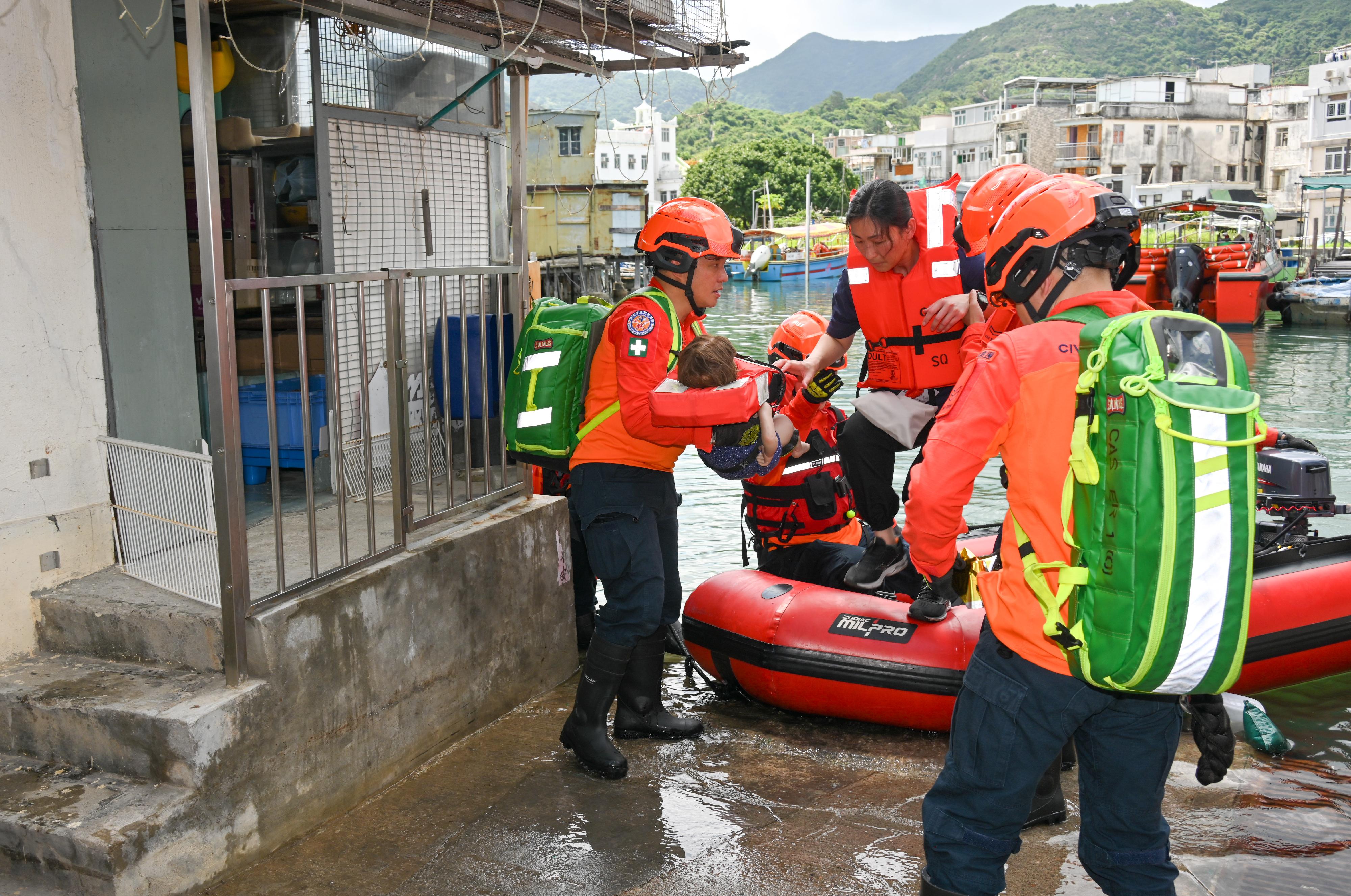 The Islands District Office conducted an interdepartmental rescue and evacuation drill in the event of flooding in Tai O today (May 15).  Photo shows Civil Aid Service members rescuing a trapped resident by an inflatable boat during the drill.