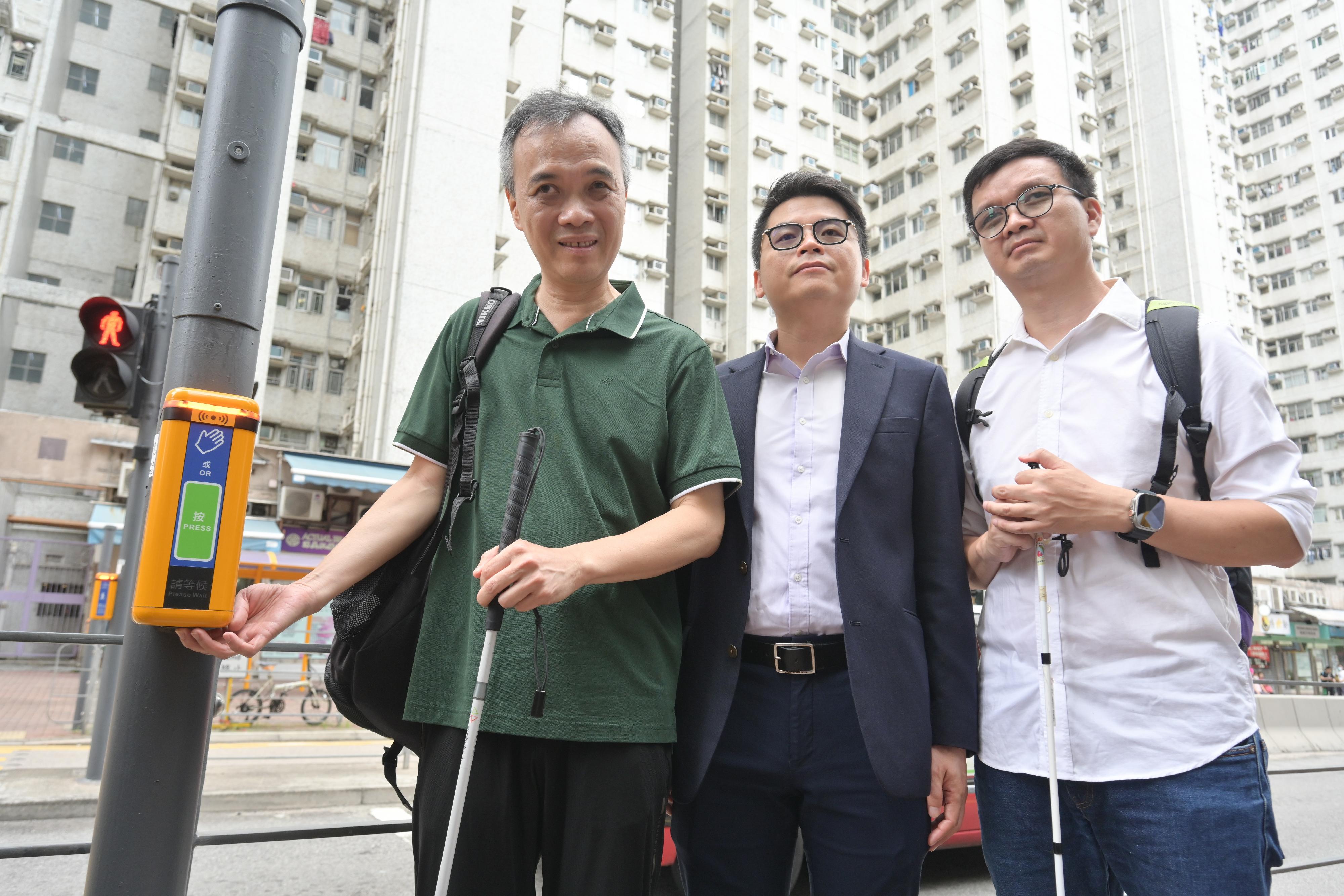 The Transport Department (TD) today (May 20) announced the territory-wide gradual renewal of electronic audible traffic signals (eATS) at signalised crossings. People-oriented new features have been incorporated to provide convenience for visually impaired persons and other members of the public. Photo shows the Chief Engineer/Traffic Control of the TD, Mr Gordon Kwok (centre), and visually impaired persons alongside the eATS at a pedestrian crossing on Hoi Wang Road (outside Charming Garden) in Yau Ma Tei.