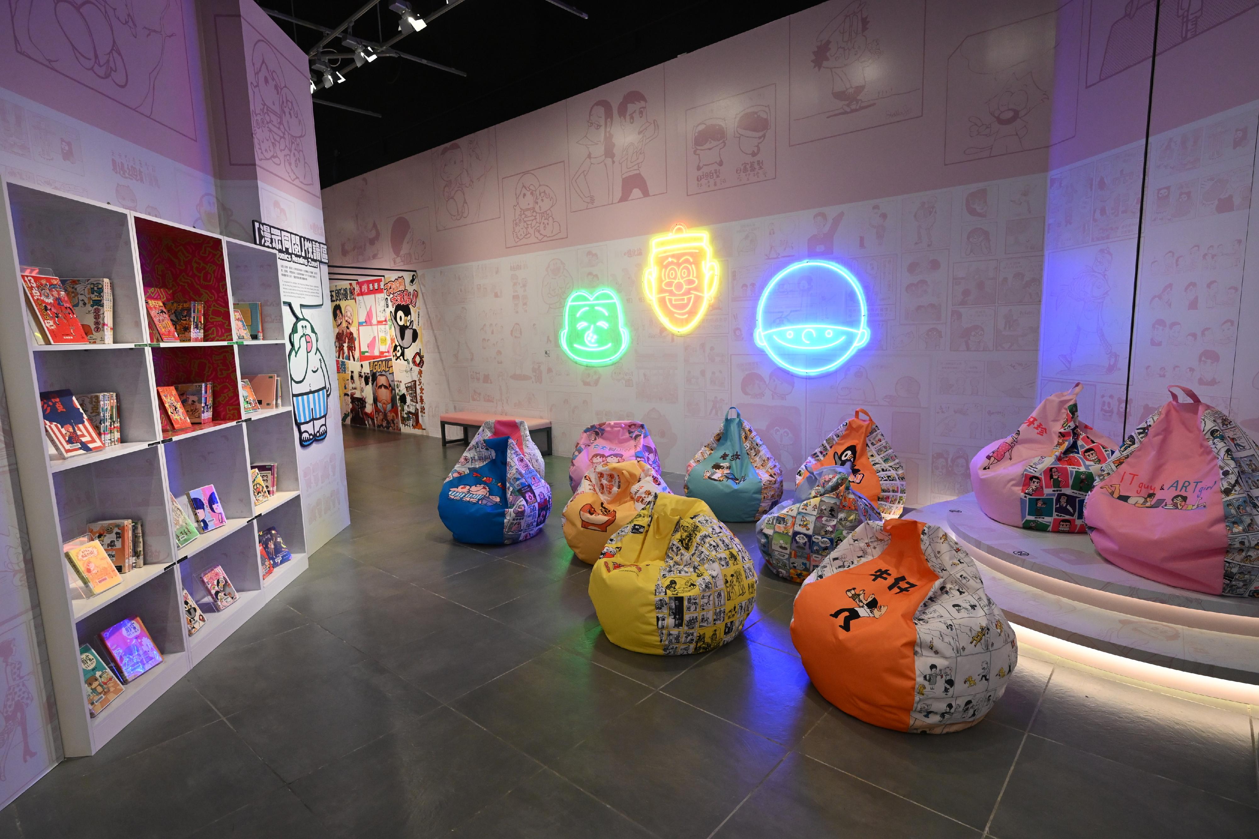 「漫眾同樂—幽默港漫格格趣」展覽明日（五月二十一日）起在香港文化博物館舉行。圖示「漫眾同閱」悅讀區和霓虹燈裝飾。