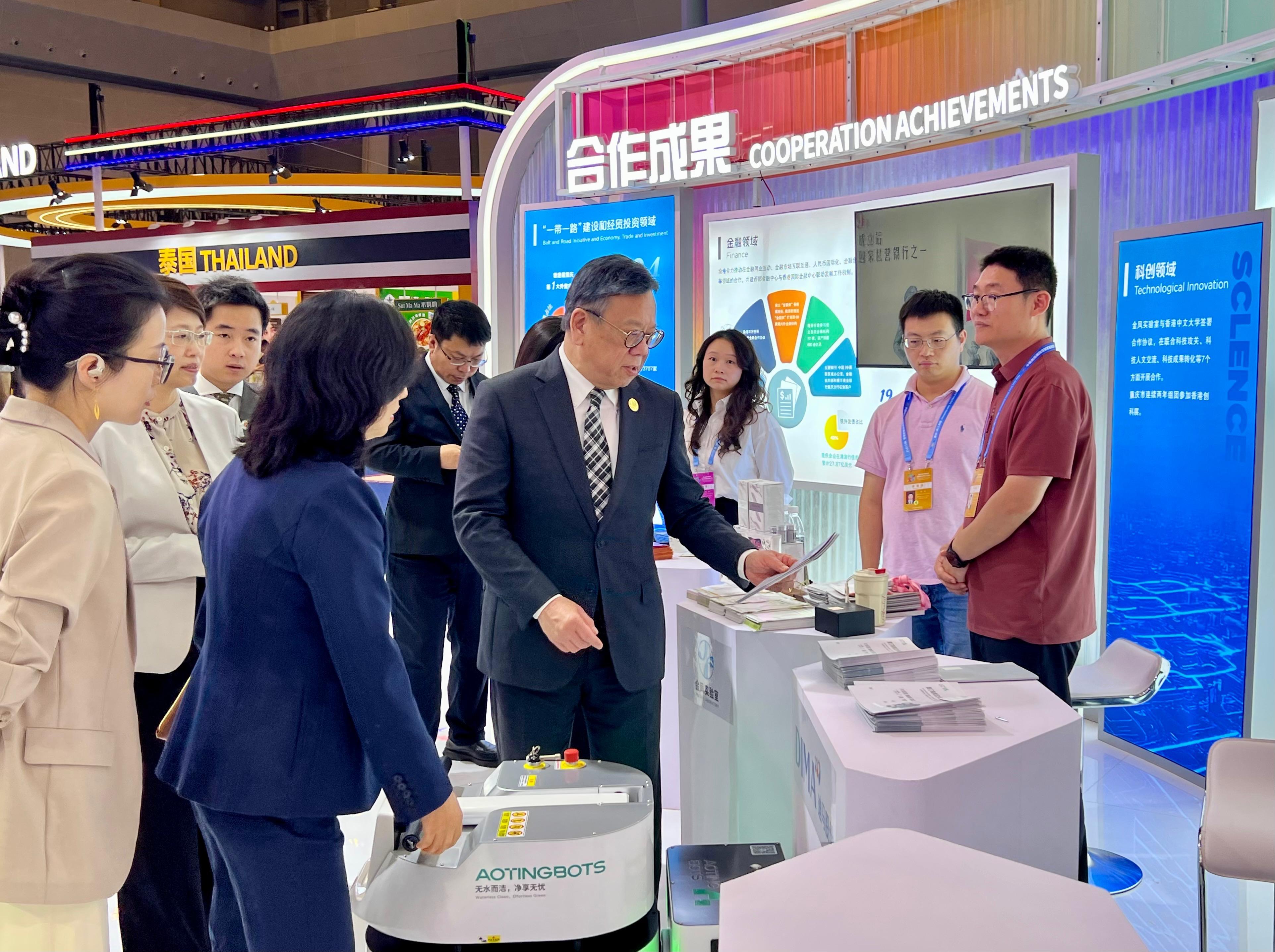The Secretary for Commerce and Economic Development, Mr Algernon Yau, attended the Seventh Western China International Fair for Investment and Trade in Chongqing today (May 22). A Hong Kong Pavilion is set up at the fair to promote Hong Kong's strengths and showcase its role as an effective and premium trade and business platform for Mainland enterprises to go global. Photo shows Mr Yau (fourth right) touring the Hong Kong Pavilion to learn about the achievements of the co-operation between Hong Kong and Chongqing in various areas.