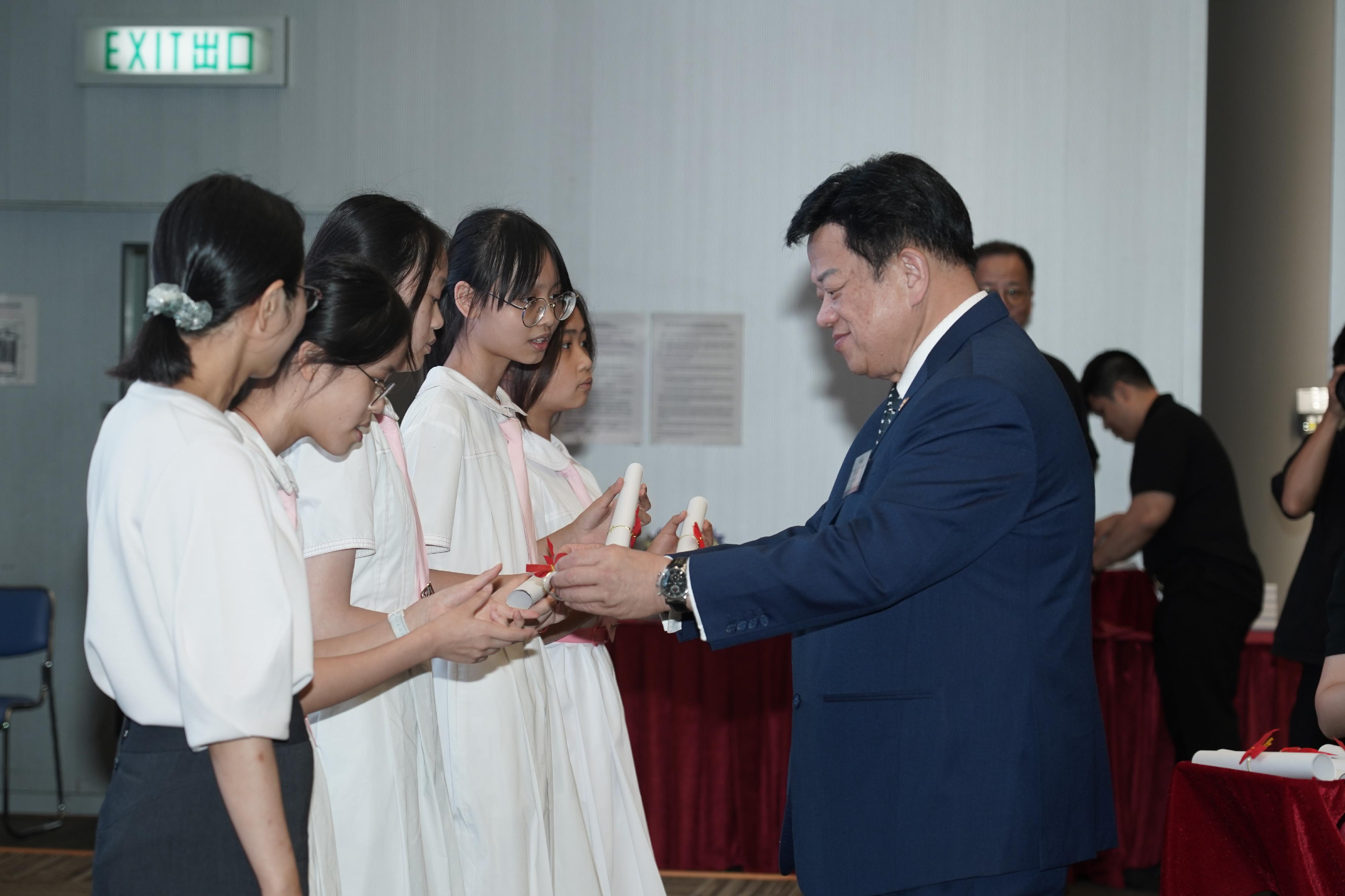 「灣區夢成真」行程設計比賽評審委員會主席龍子明（右）今日（五月二十三日）在「慶祝『薪火相傳』國民教育活動系列平台成立 15周年：學生內地交流計劃『灣區夢成真』行程設計比賽」頒獎典禮頒發獎項予獲獎隊伍。