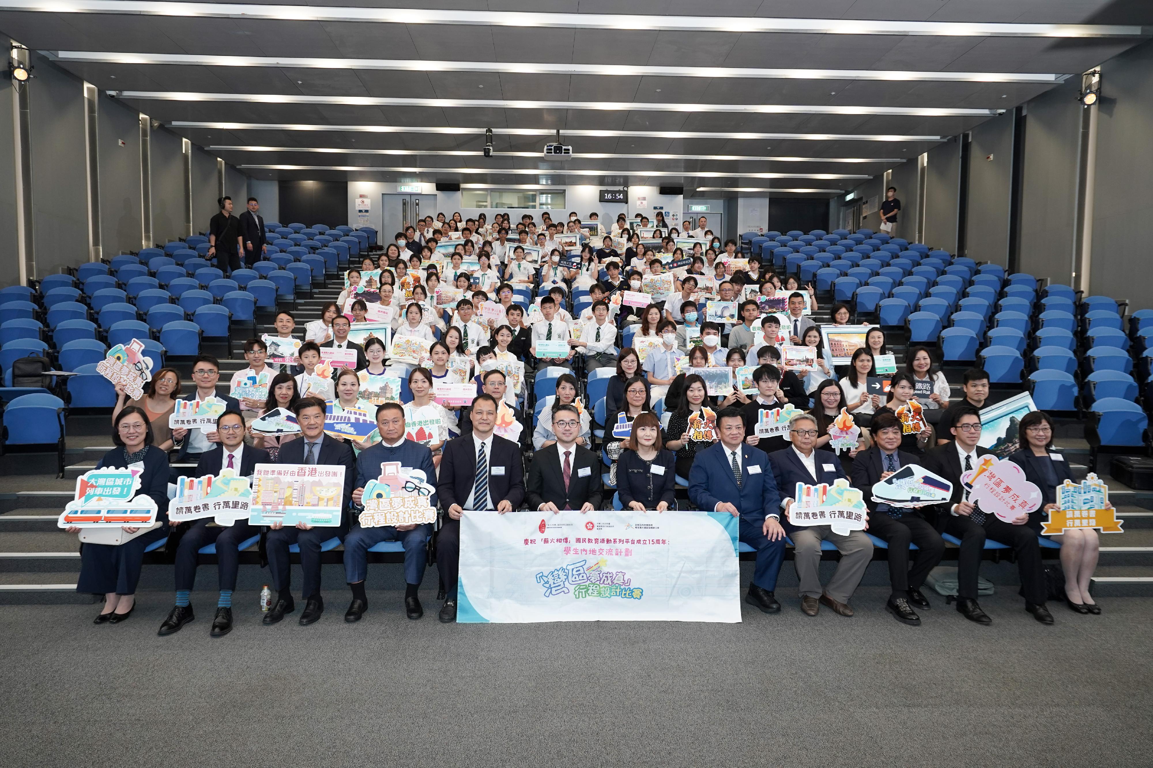 「慶祝『薪火相傳』國民教育活動系列平台成立 15周年：學生內地交流計劃『灣區夢成真』行程設計比賽」頒獎典禮今日（五月二十三日）舉行。圖示教育局副局長施俊輝（前排左六）、粵港澳大灣區發展專員陳潔玲（前排右六）、中央人民政府駐香港特別行政區聯絡辦公室青年工作部二級巡視員張國來（前排左五）、「灣區夢成真」行程設計比賽評審委員會主席龍子明（前排右五）與其他嘉賓和師生合照。