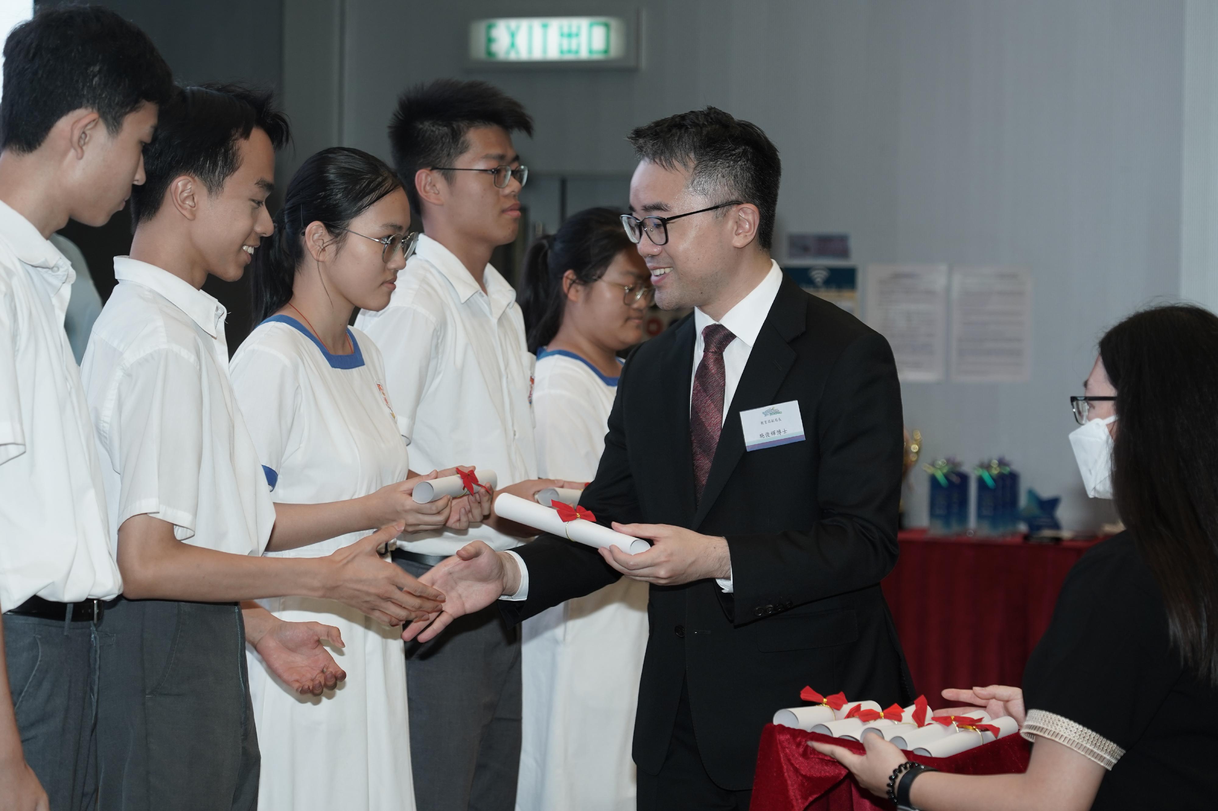 The Under Secretary for Education, Dr Sze Chun-fai (right), presents the award to the winning team at the Award Presentation Ceremony for Celebration of the 15th Anniversary of the Founding of the "Passing on the Torch" National Education Activity Series Platform: "Dreams to Greater Bay Area Come True" Itinerary Design Competition under Mainland Exchange Programmes for Students today (May 23).