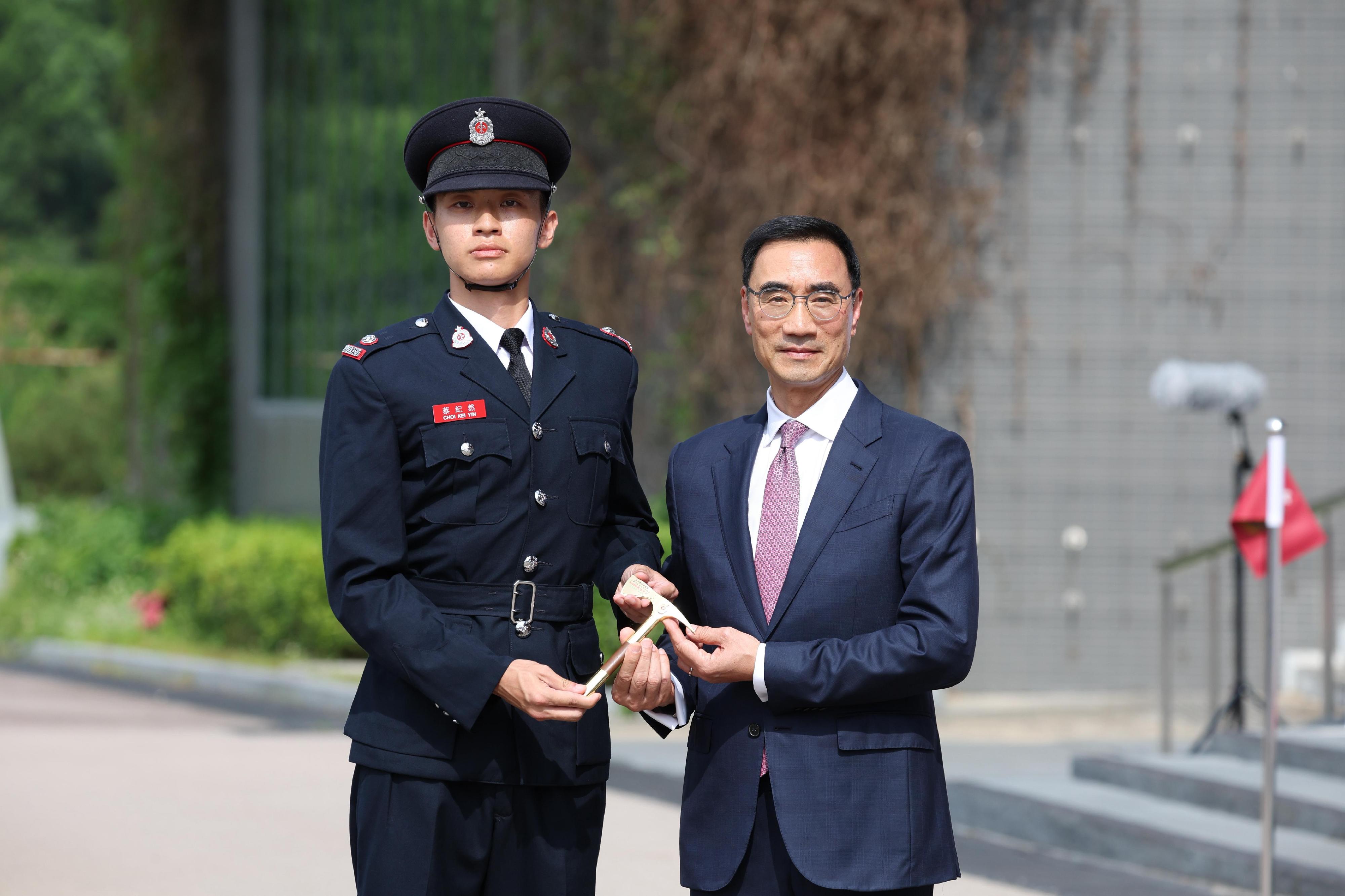 The Chairman of the Hong Kong Jockey Club, Mr Michael Lee, reviewed the Fire Services passing-out parade at the Fire and Ambulance Services Academy today (May 23). Photo shows Mr Lee (right) presenting the Best Recruit Station Officer award to a graduate.