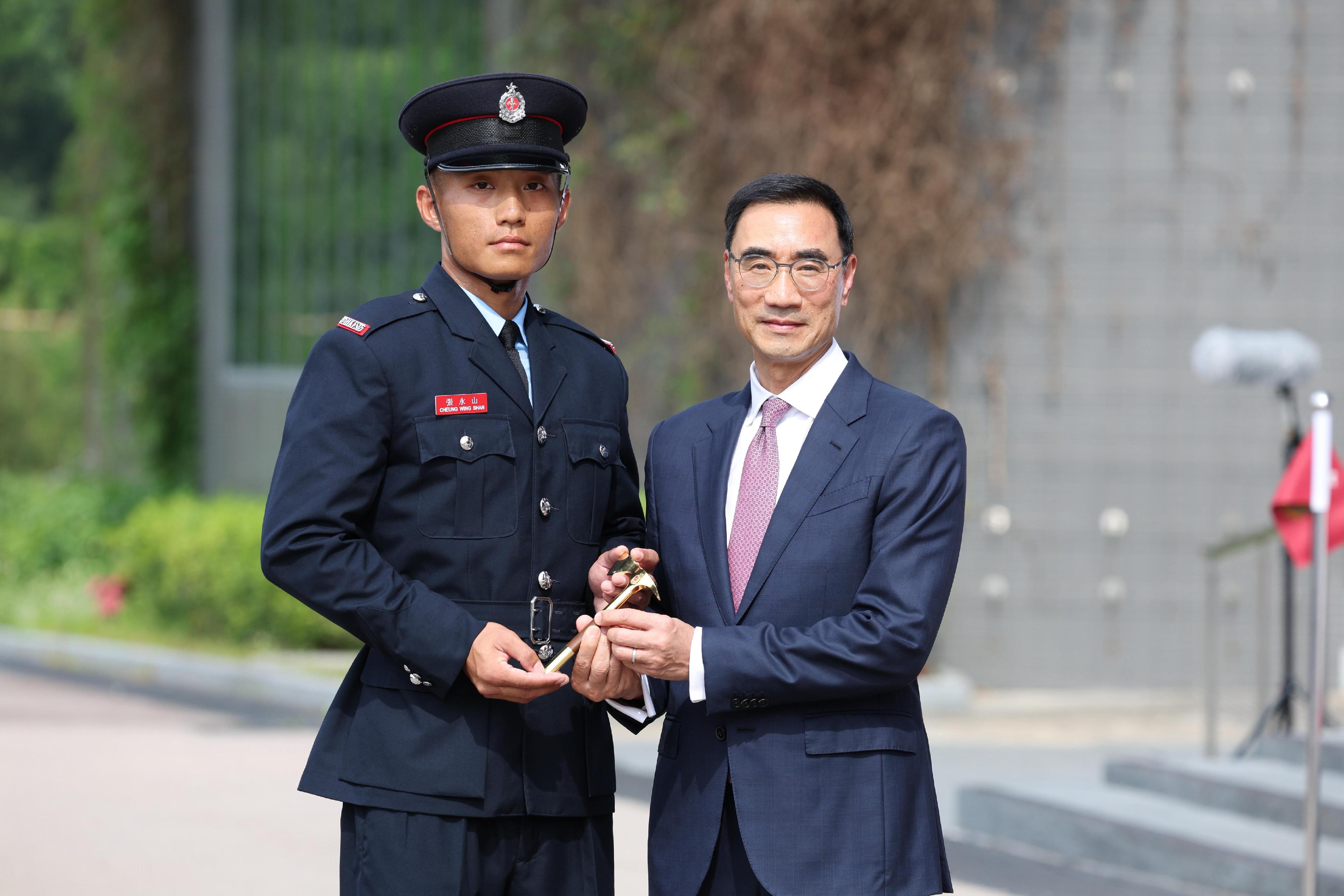 The Chairman of the Hong Kong Jockey Club, Mr Michael Lee, reviewed the Fire Services passing-out parade at the Fire and Ambulance Services Academy today (May 23). Photo shows Mr Lee (right) presenting the Best Recruit Fireman award to a graduate.