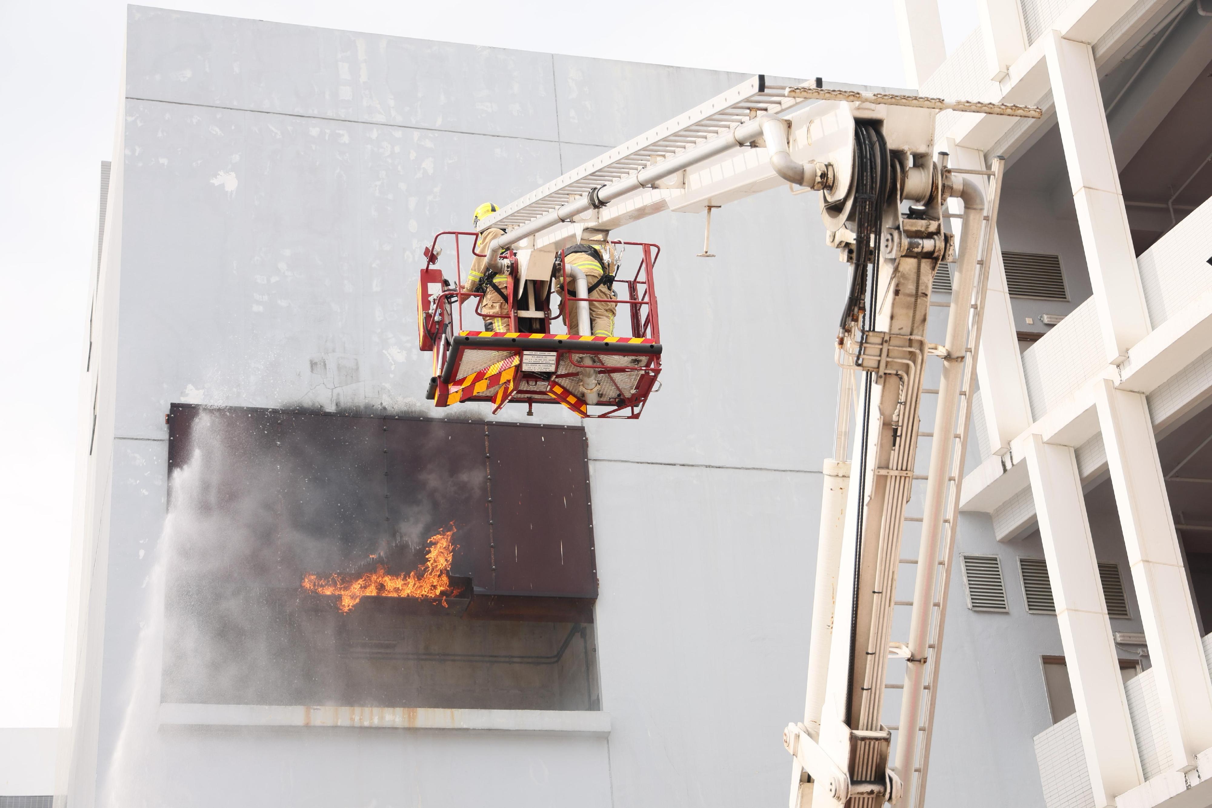 The Chairman of the Hong Kong Jockey Club, Mr Michael Lee, reviewed the Fire Services passing-out parade at the Fire and Ambulance Services Academy today (May 23). Photo shows graduates demonstrating firefighting techniques.