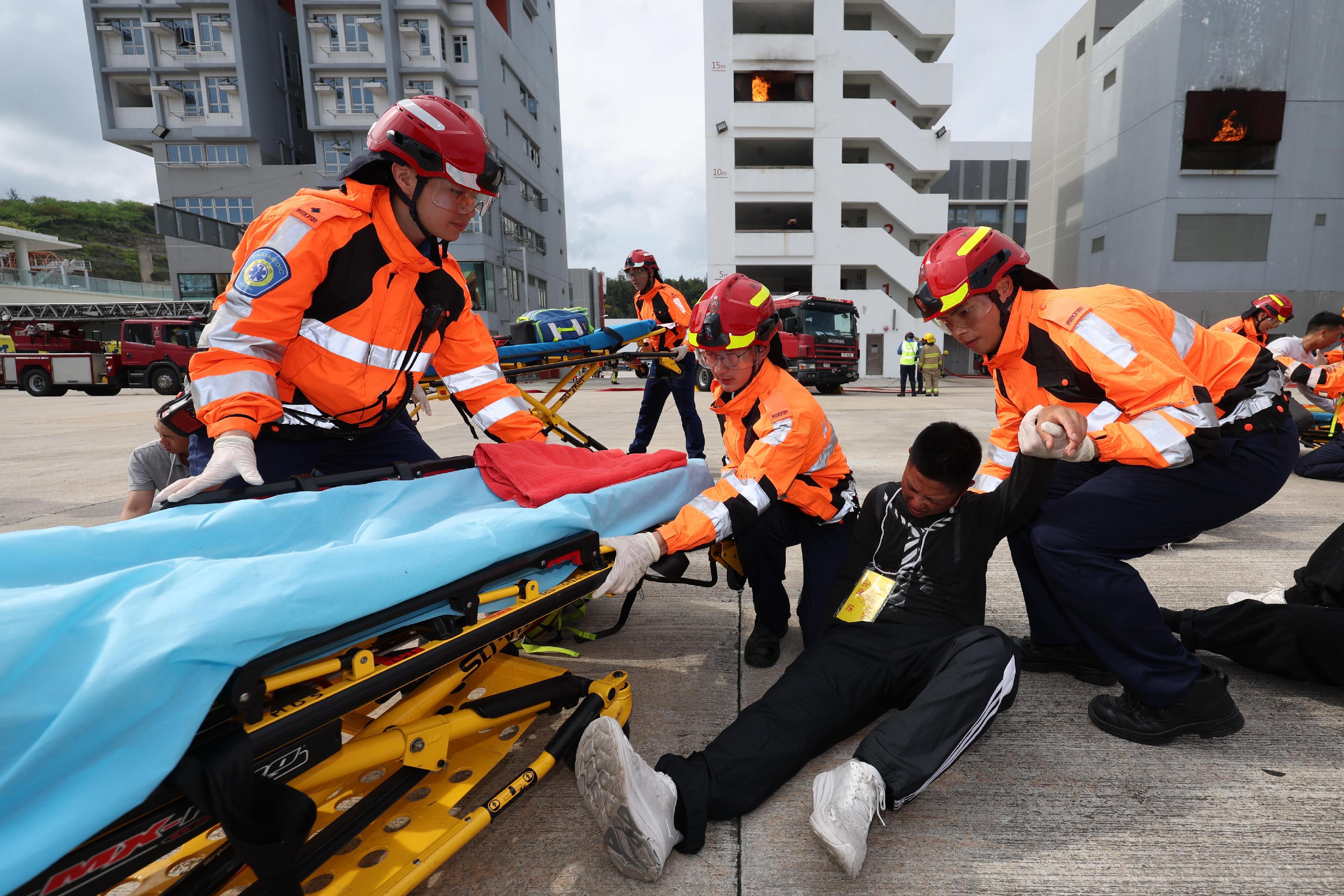 The Chairman of the Hong Kong Jockey Club, Mr Michael Lee, reviewed the Fire Services passing-out parade at the Fire and Ambulance Services Academy today (May 23). Photo shows graduates demonstrating rescue techniques.