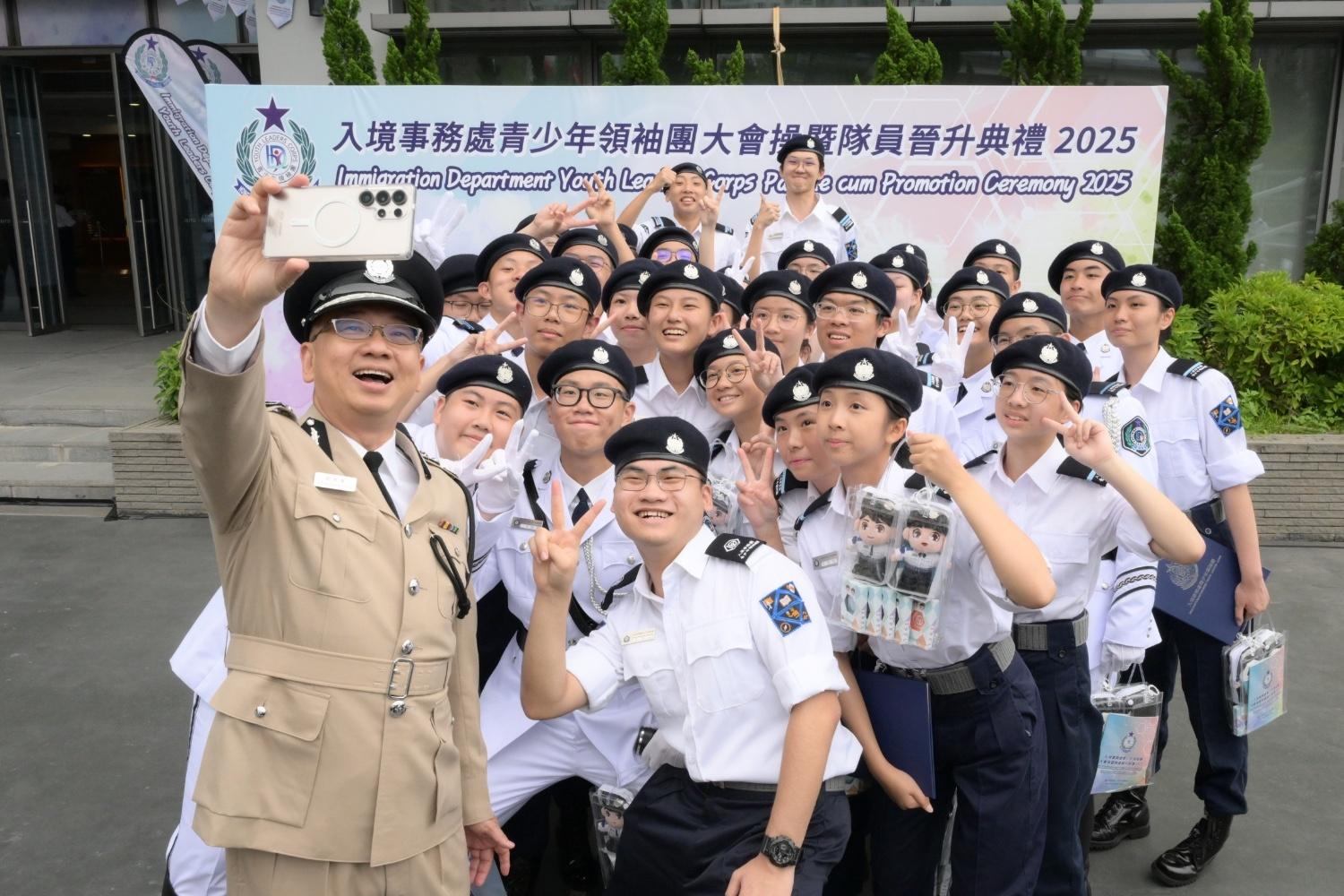 The Immigration Department held the Grand Immigration Department Youth Leaders Corps (IDYL) Parade cum Promotion Ceremony 2025 at the Immigration Service Institute of Training and Development in Tuen Mun today (May 25). Photo shows the Director of Immigration, Mr Benson Kwok (first left) and members of the parade taking a selfie after the event.
