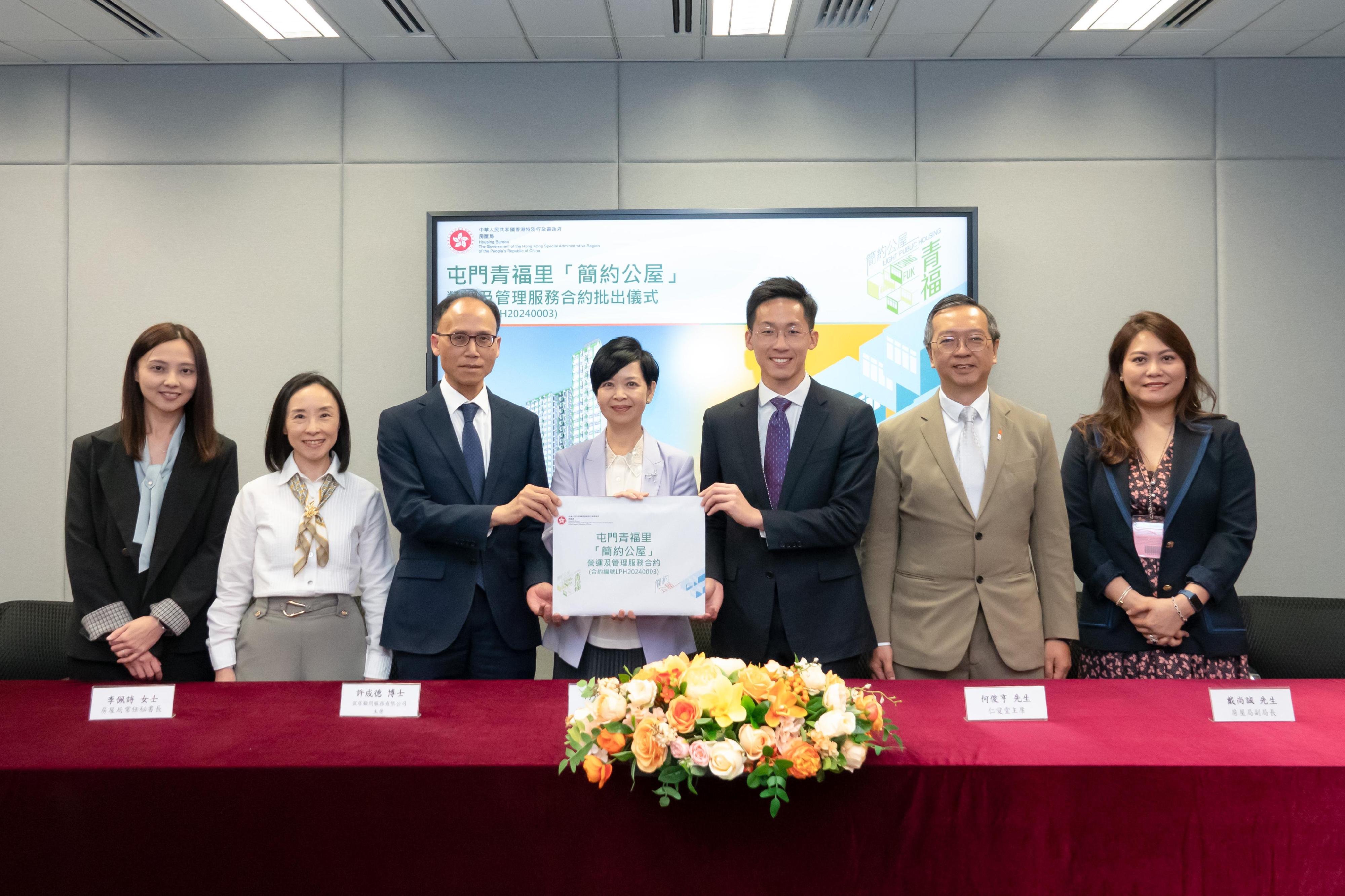 房屋局今日（五月二十六日）批出兩份「簡約公屋」項目的營運及管理服務合約。圖示房屋局局長何永賢（中）、房屋局常任秘書長李佩詩（左二）及房屋局副局長戴尚誠（右二）在批出合約的儀式上，與屯門青福里（即屯門第3A區）「簡約公屋」項目營運及管理服務合約（合約編號LPH20240003）的中標機構宜居顧問服務有限公司——仁愛堂有限公司聯營代表合照。