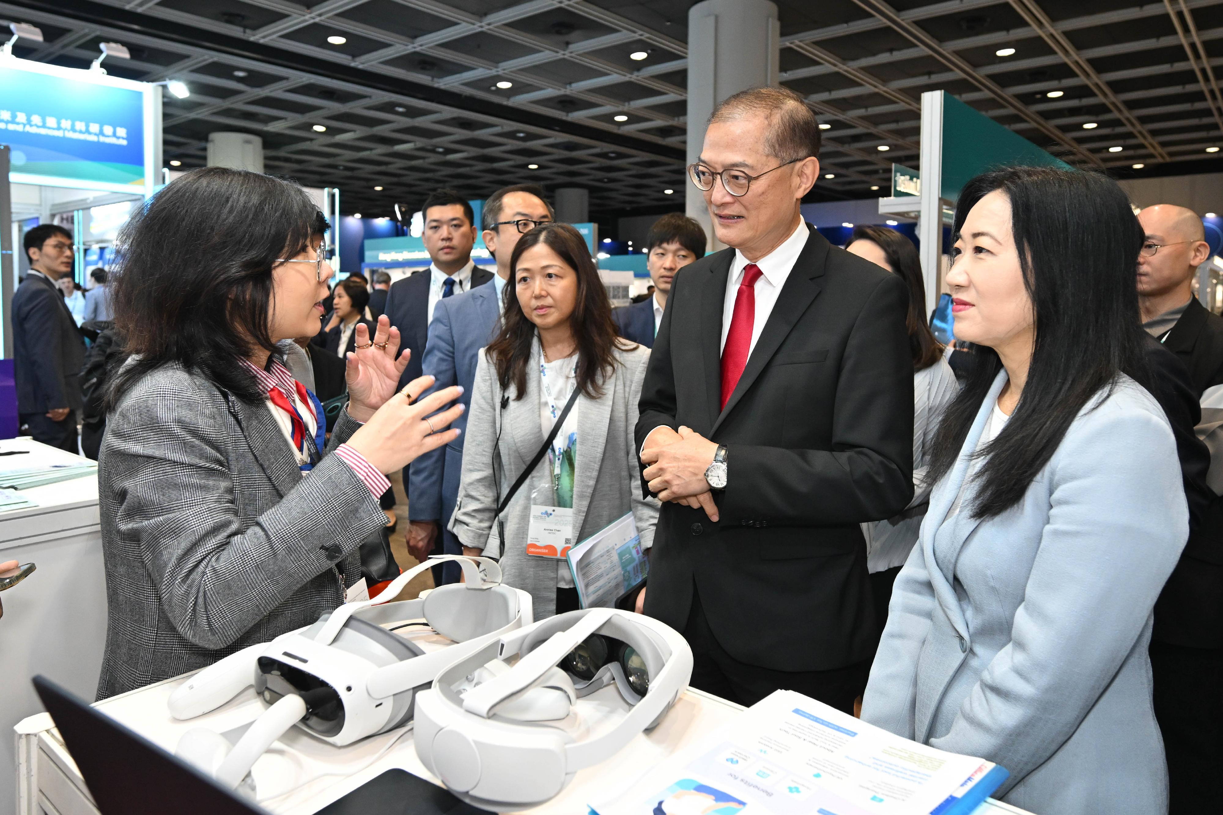 The Secretary for Health, Professor Lo Chung-mau (second right), tours an exhibition booth set up at the Asia Summit on Global Health today (May 26).