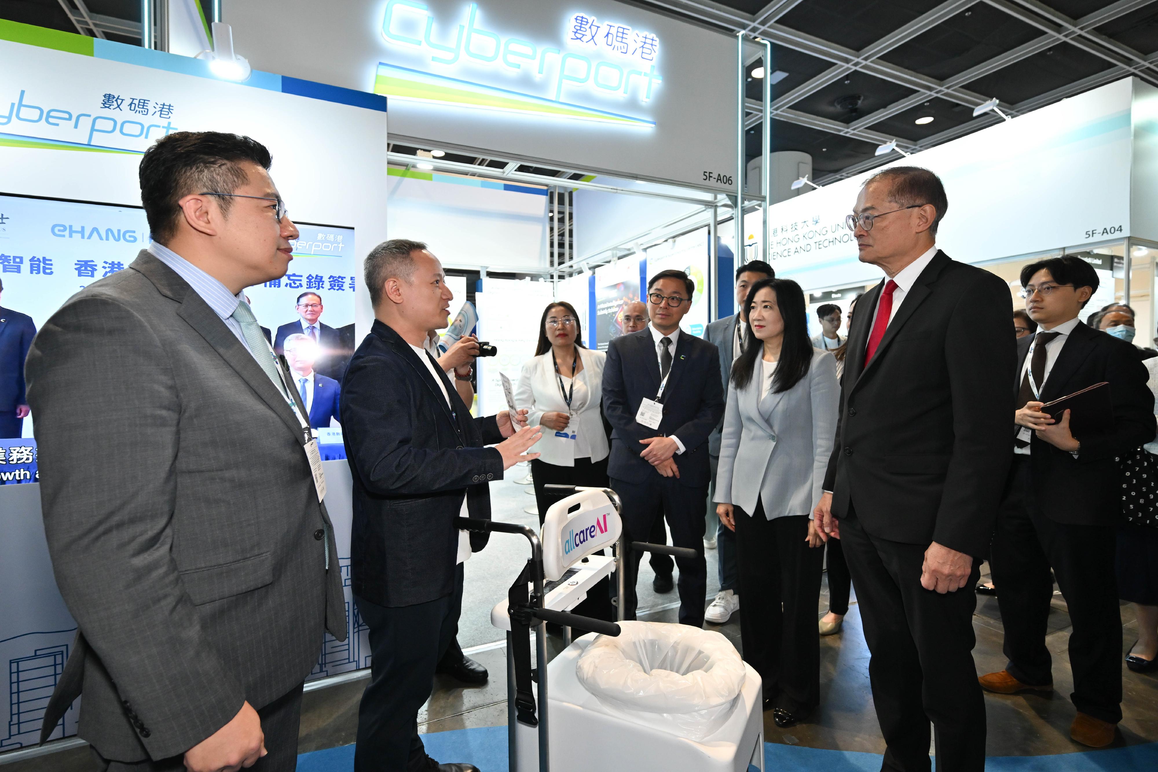 The Secretary for Health, Professor Lo Chung-mau (second right), tours an exhibition booth set up at the Asia Summit on Global Health today (May 26).