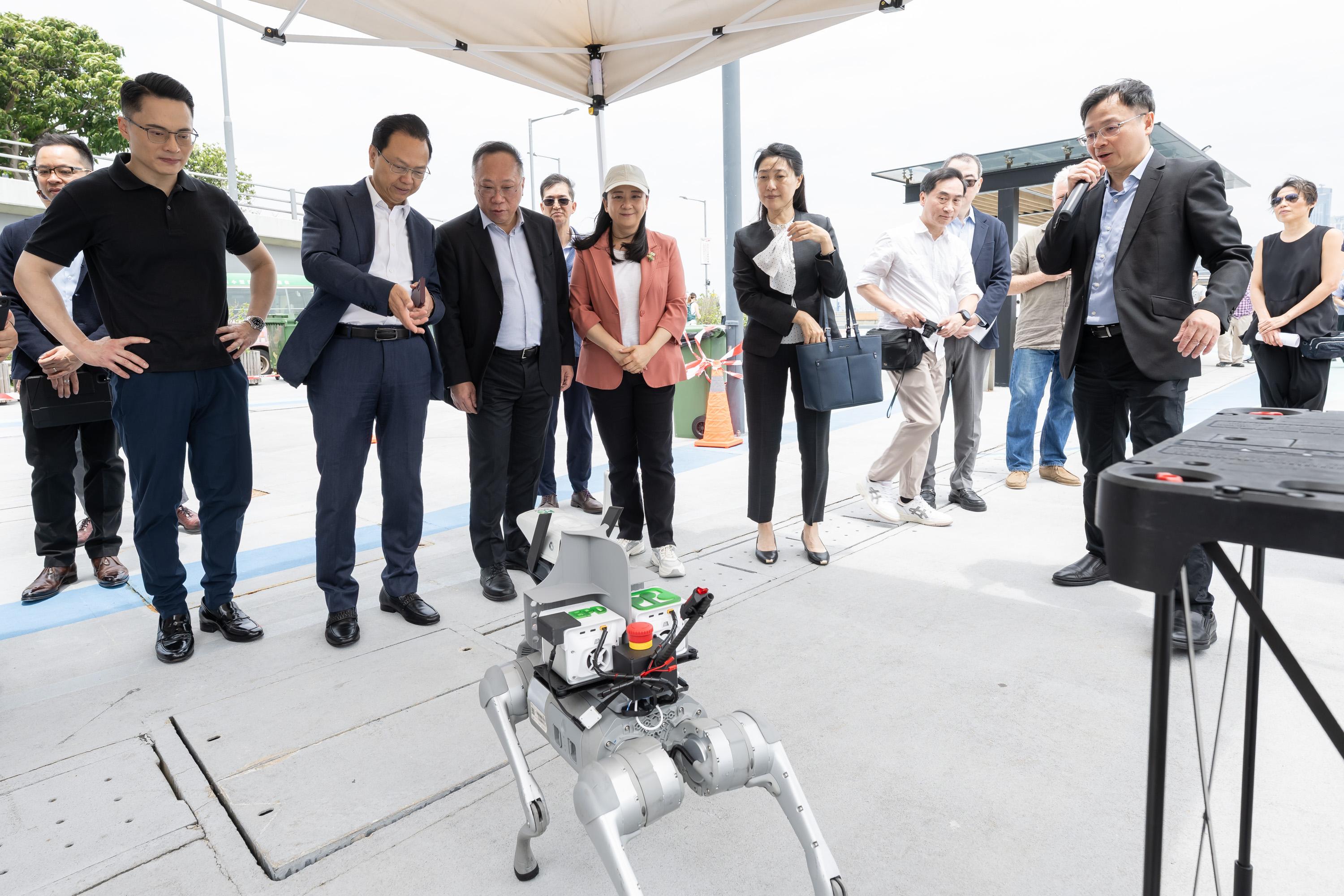 The Legislative Council Subcommittee on Matters Relating to the Development of Smart City observed a demonstration of "Smart Environment" at Wan Chai promenade today (May 27). Photo shows Members observing a demonstration of an "AI robotic dog" tracing pollution sources.
