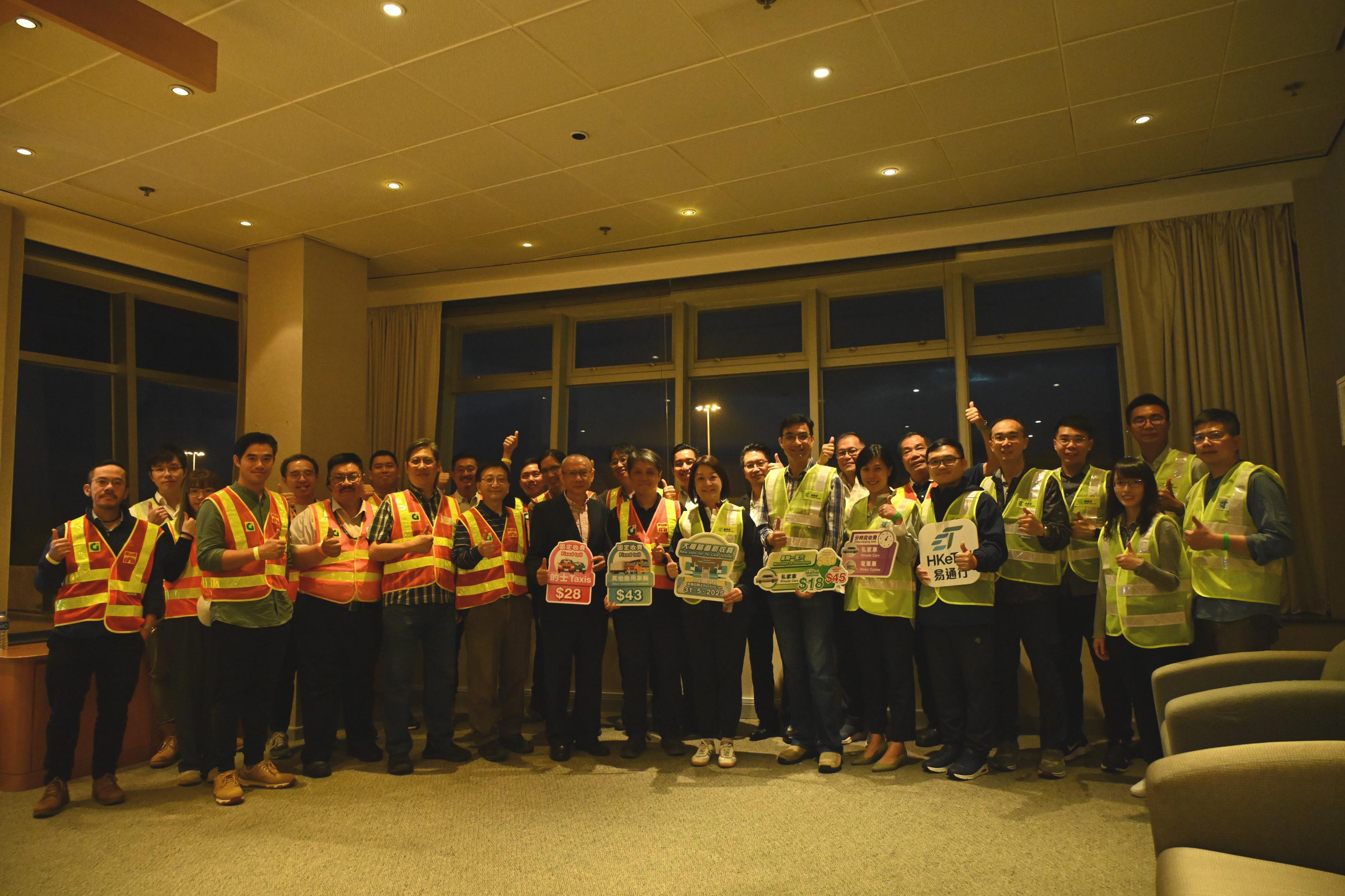 The Government took over the Tai Lam Tunnel (TLT) at 0.00am today (May 31), and implemented the new tolls and the HKeToll. The Commissioner for Transport, Ms Angela Lee, visited the TLT Administration Building in the small hours to ensure a safe and smooth takeover. Photo shows Ms Lee (front row, fourth right), accompanied by the Deputy Commissioner for Transport/Planning and Technical Services, Mr Patrick Ho (front row, third right), and the Deputy Director of Highways, Mr Richard Ng (front row, fifth right), and staff of government departments and the operator.