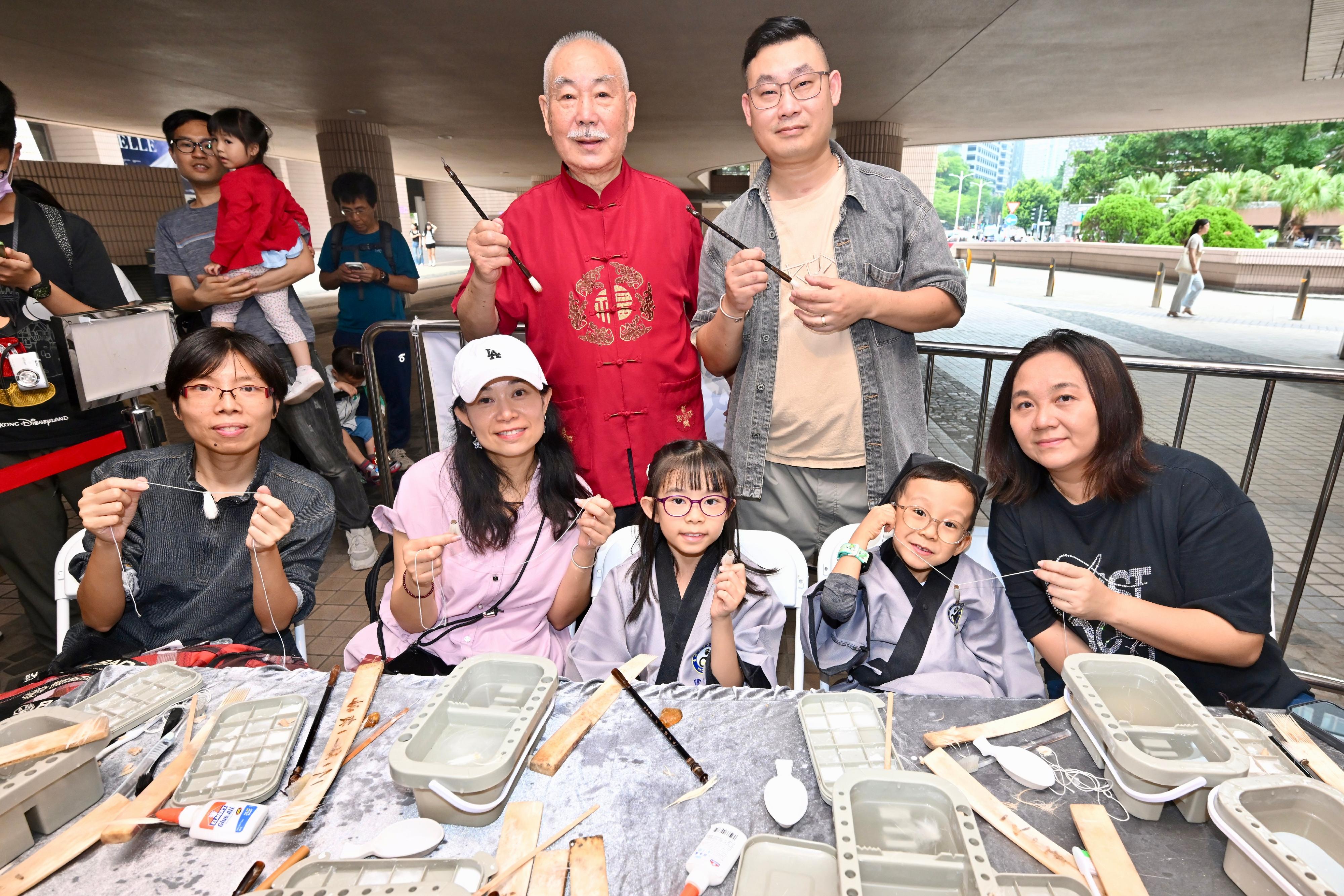 非物質文化遺產辦事處於今明（五月三十一日和六月一日）兩日在香港文化中心露天廣場舉行非遺嘉年華。圖示市民在互動攤位體驗毛筆製作技藝。

