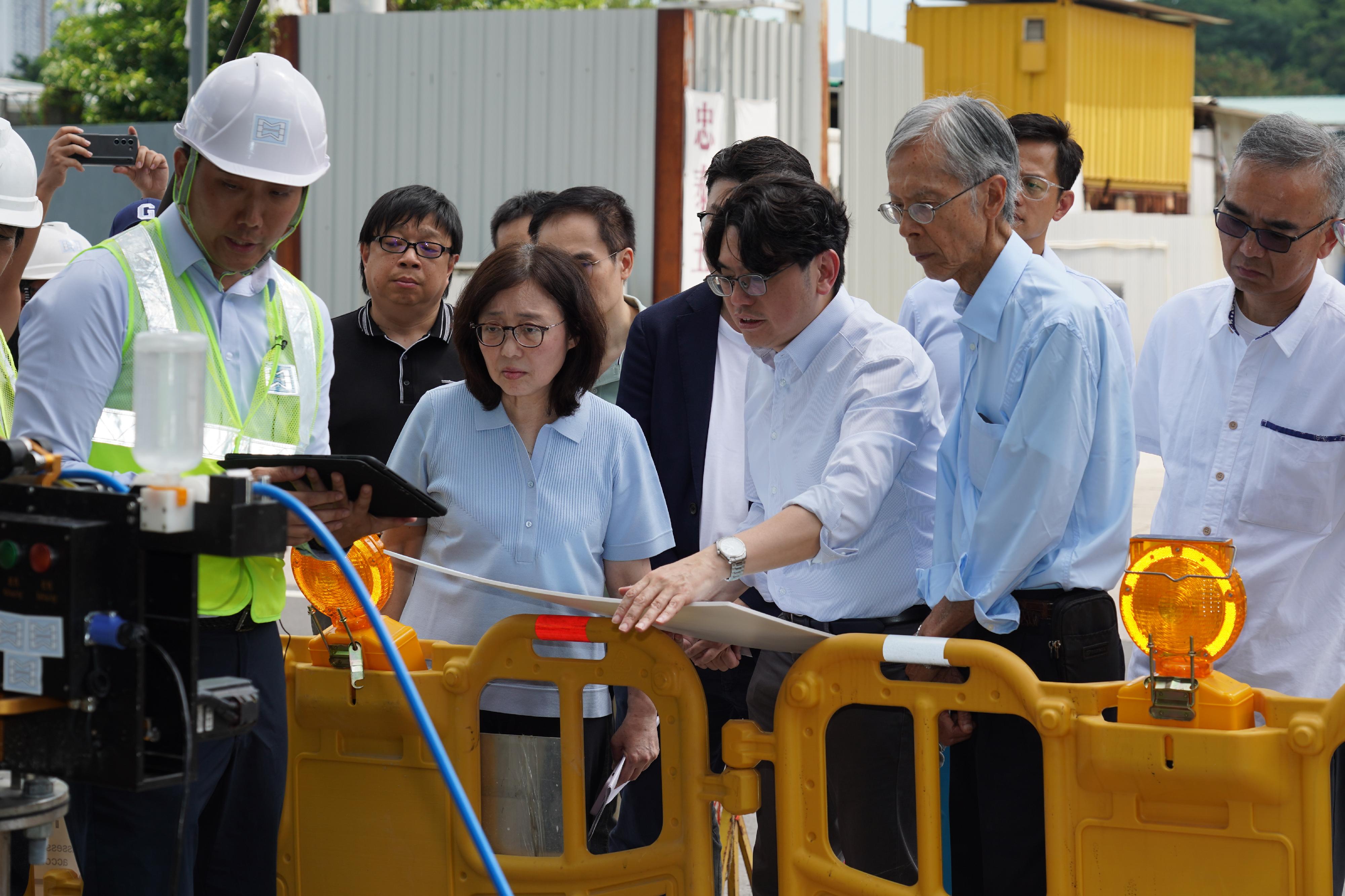 The Secretary for Development, Ms Bernadette Linn; the Director of Water Supplies, Mr Roger Wong; and the expert group of the Drinking Water Safety Advisory Committee inspected the fresh water supply network for Queen's Hill Estate and Shan Lai Court today (June 7). Photo shows Ms Linn (front row, second left) being briefed by Mr Wong (front row, third left) on the use of advanced technology to check the condition inside water pipes at Ping Che Road.