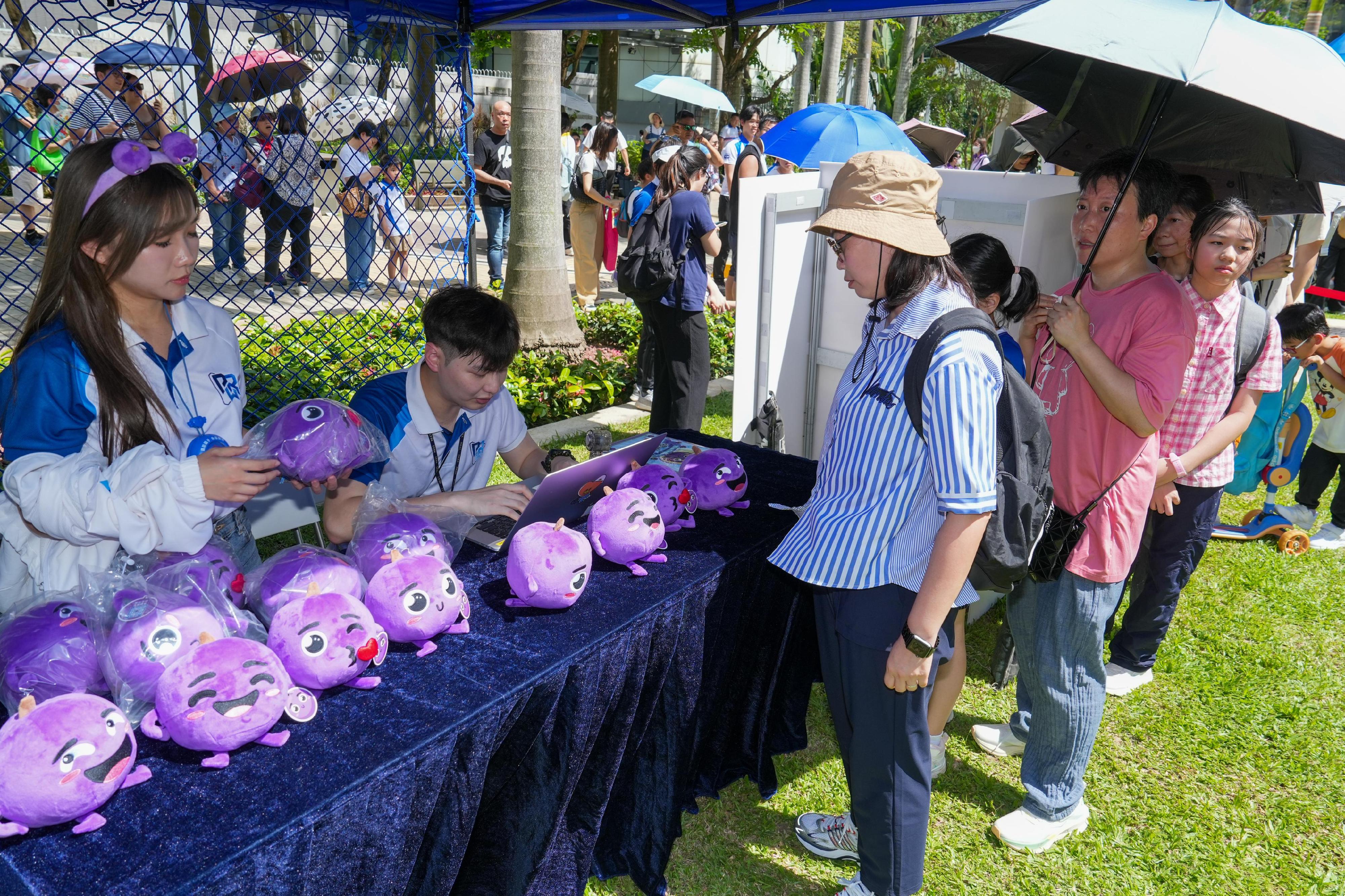 The Hong Kong Police Force organises the "The Little Grape’s 5th Anti-Scam Birthday Party" at the Harcourt Garden in Admiralty today (June 8). Photos shows members of the public participating in a game booth to learn more about prevalent types of scams.