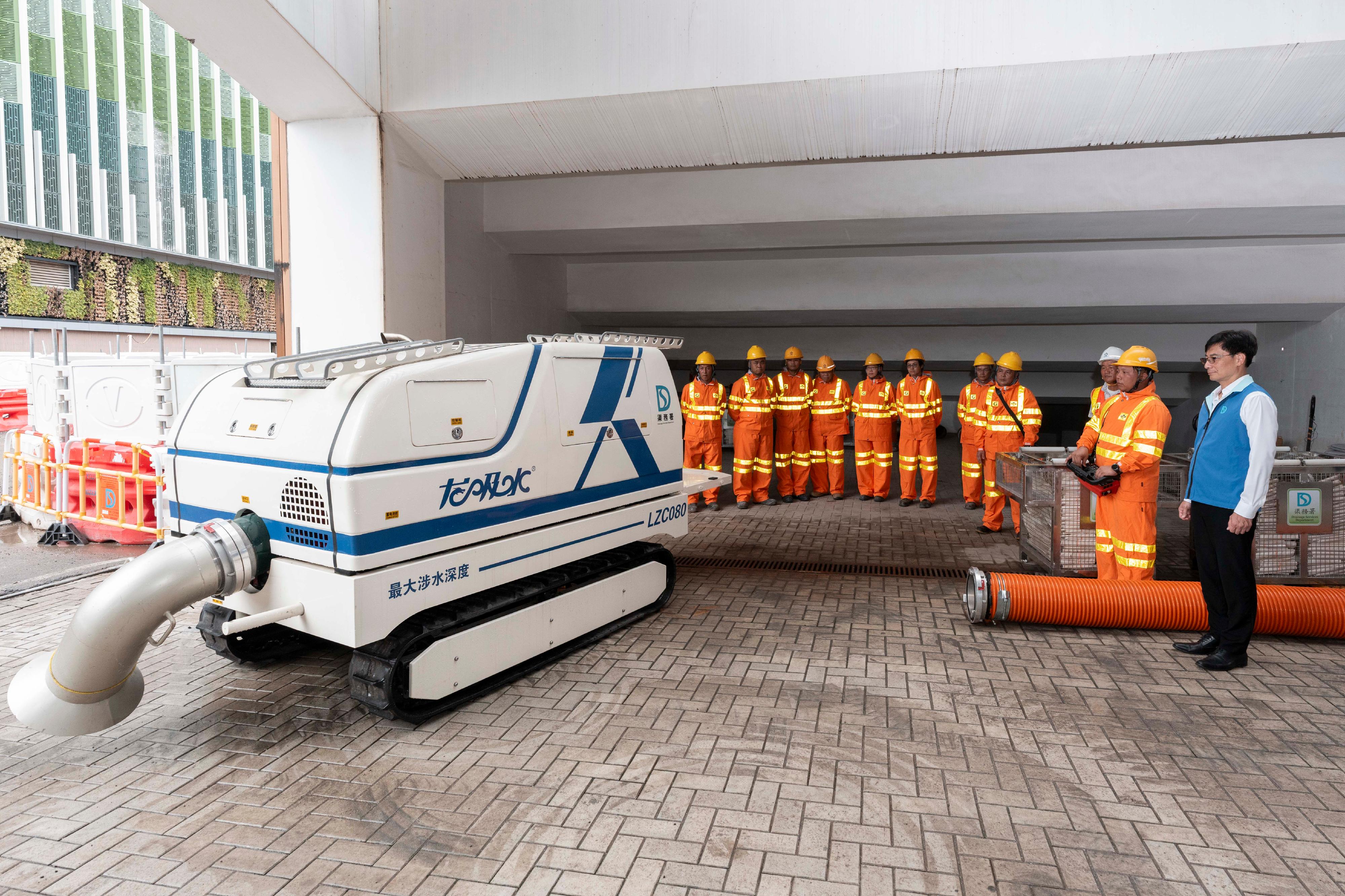 Officers of the Drainage Services Department inspected locations that had been hit by severe flooding in the past on June 11 to learn about the flood prevention measures implemented by the department. Photo shows the Director of Drainage Services, Mr Ringo Mok (first right), inspecting the Mobile Powerful Pumping Robot and Amphibious Pumping Robot to ensure the readiness of flood prevention facilities.