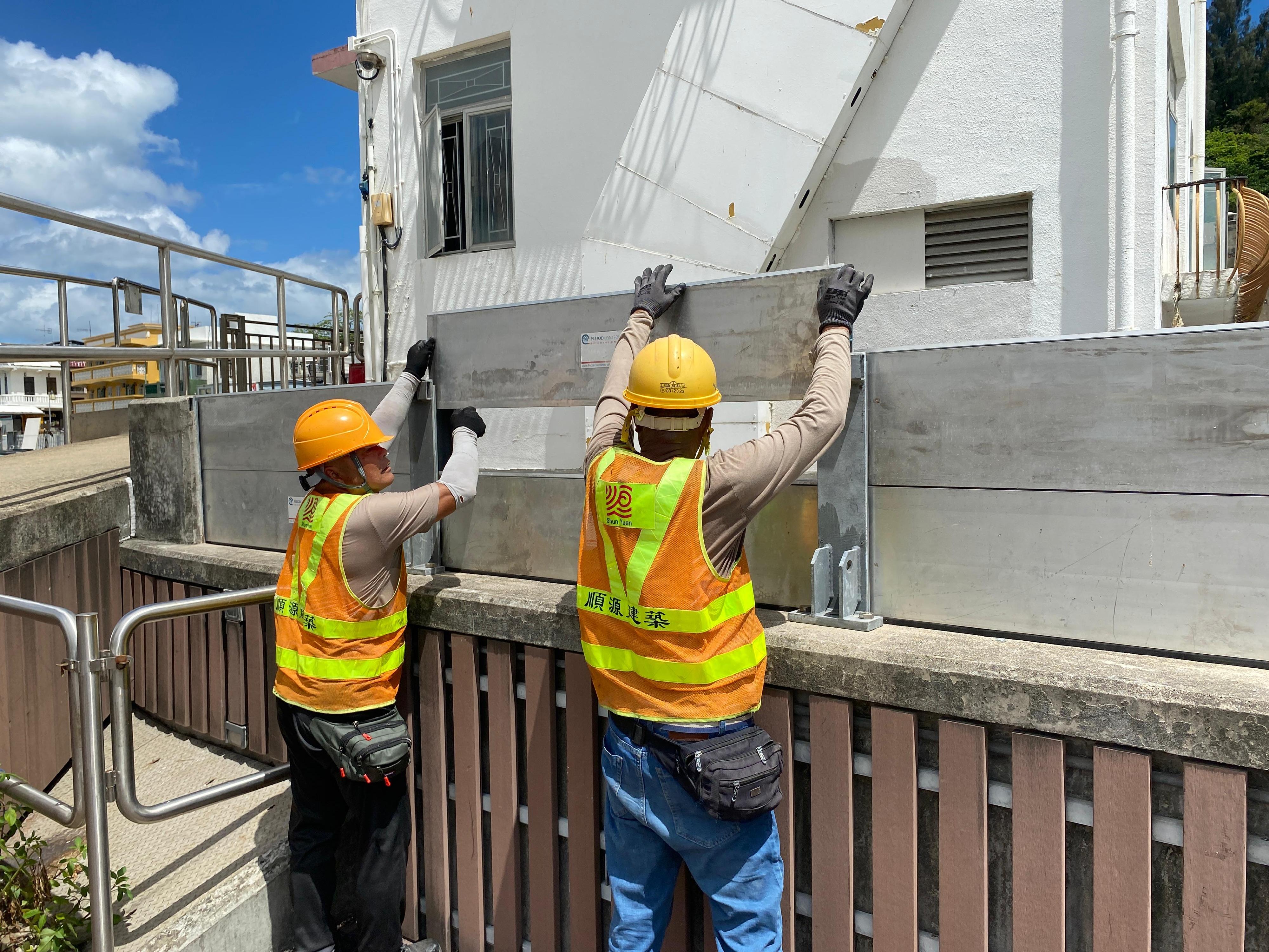 Officers of the Drainage Services Department (DSD) inspected locations that had been hit by severe flooding in the past on June 11 to learn about the flood prevention measures implemented by the department. Photo shows DSD staff installing demountable flood barriers in Tai O.