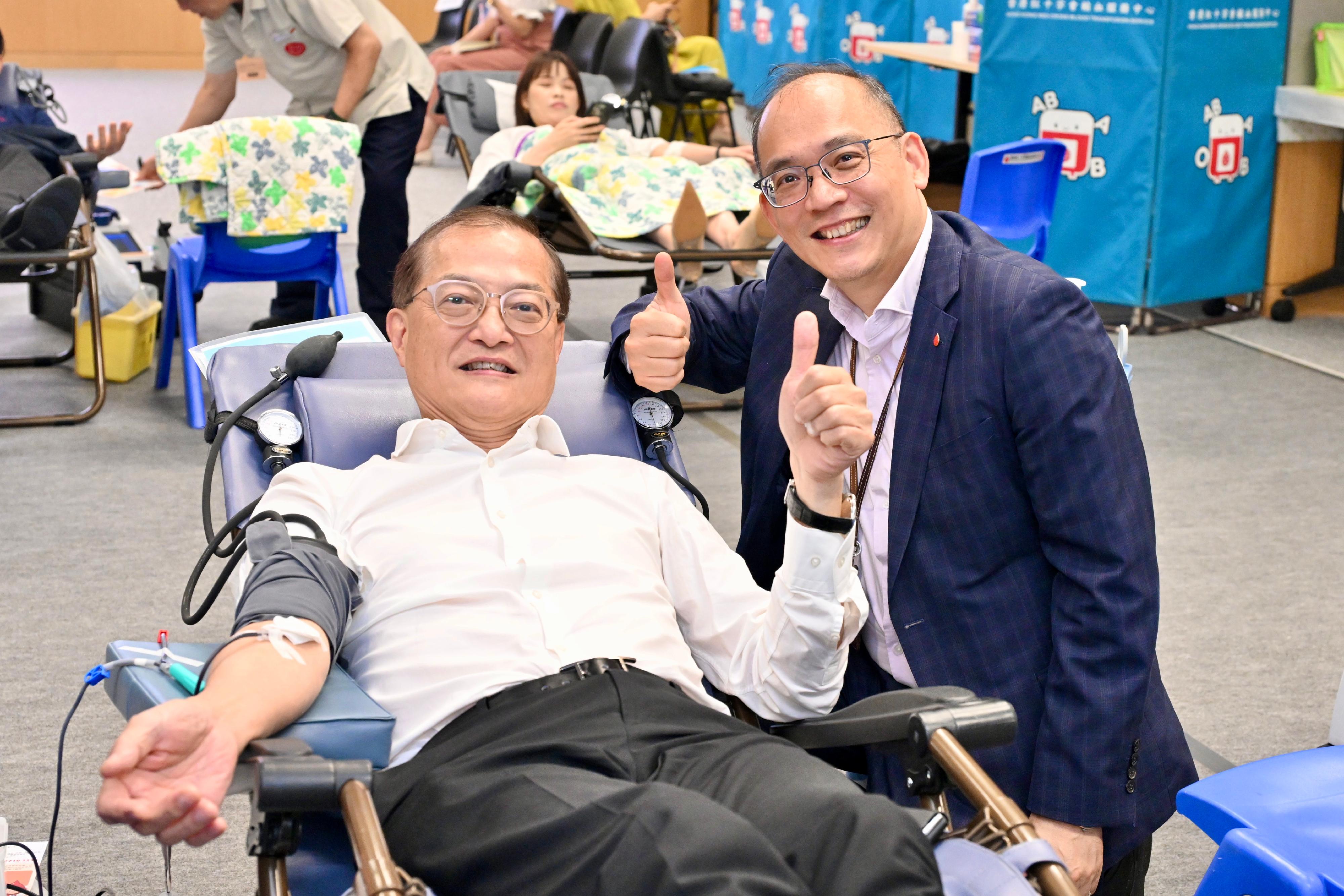 The Secretary for Health, Professor Lo Chung-mau, put his support for saving lives through blood donation into practical action by participating in the blood donation drive being held by the Hong Kong Red Cross at the Central Government Offices today (June 12). Next to him is the Chief Executive and Medical Director of the Hong Kong Red Cross Blood Transfusion Service, Dr Lee Cheuk-kwong (right).