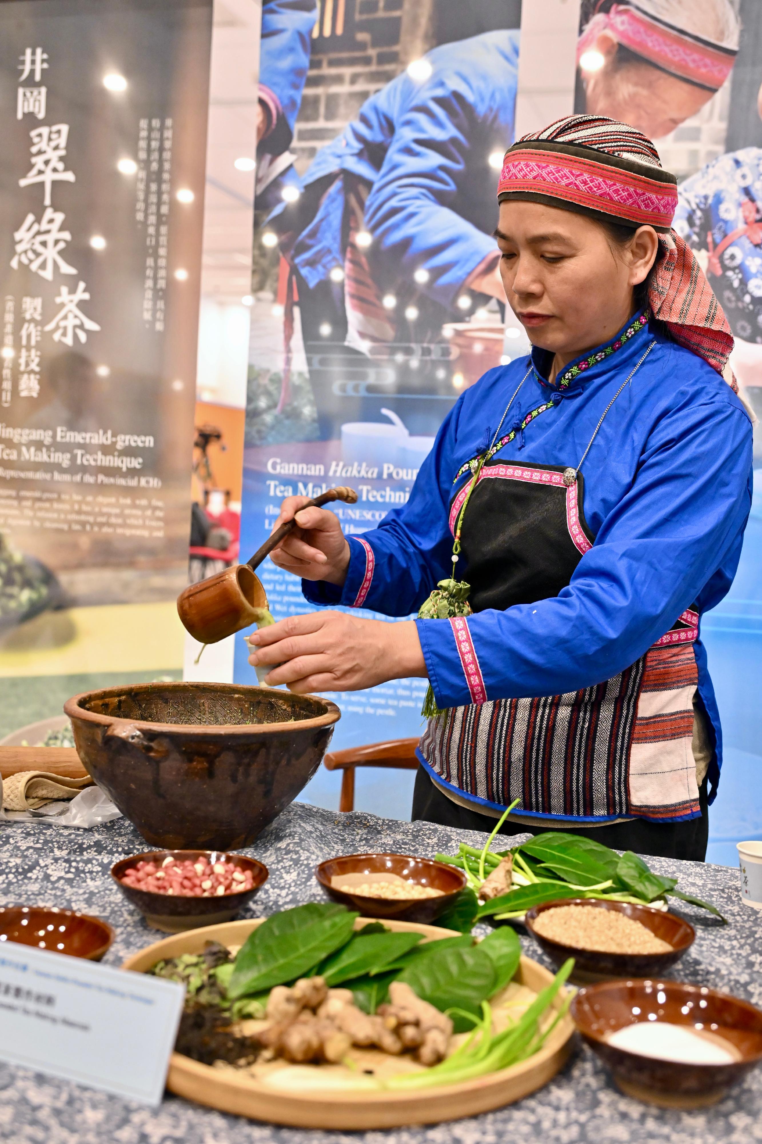 The opening ceremony for "Genesis and Spirit - Treasures of Nature · Extraordinary Hakka: Intangible Cultural Heritage Exhibition of Jiangxi" was held today (June 13) at the Hong Kong Central Library. Photo shows a demonstration of an item inscribed onto the United Nations Educational, Scientific and Cultural Organization's Representative List of the ICH of Humanity, Gannan Hakka Pounded Tea Making Technique, given by the bearer.  
