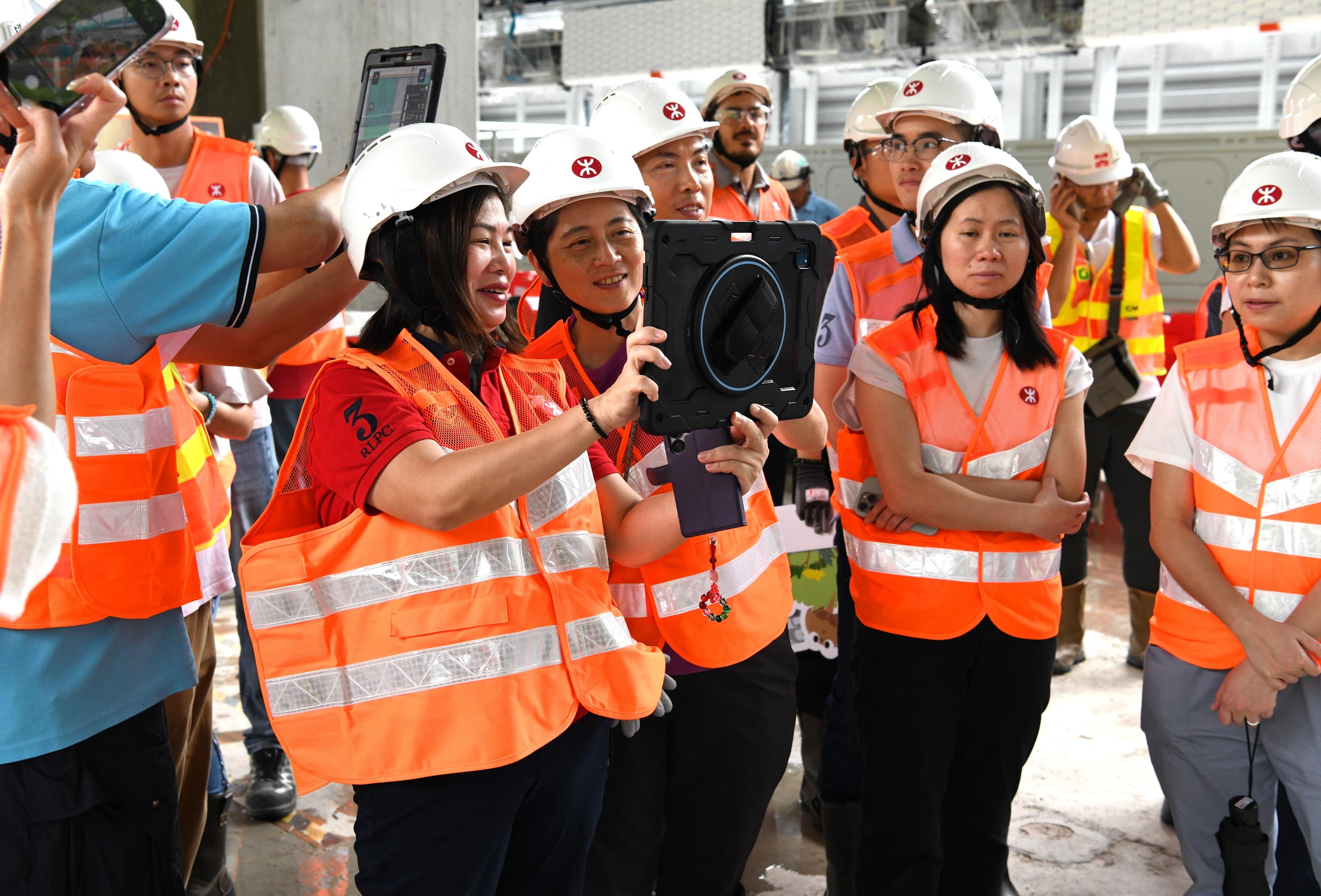 The two-day International Conference on Roads and Railways 2025 co-organised by the Highways Department and the Hong Kong Institution of Highways and Transportation successfully concluded yesterday (June 13). The participants were arranged to visit the works sites of the Central Kowloon Route and the MTR Corporation Limited (MTRCL) Tung Chung Line Extension (TUE) projects respectively today (June 14). Photo shows the delegation experiencing the virtual tour at the Tung Chung East Station works site of the MTRCL TUE project.