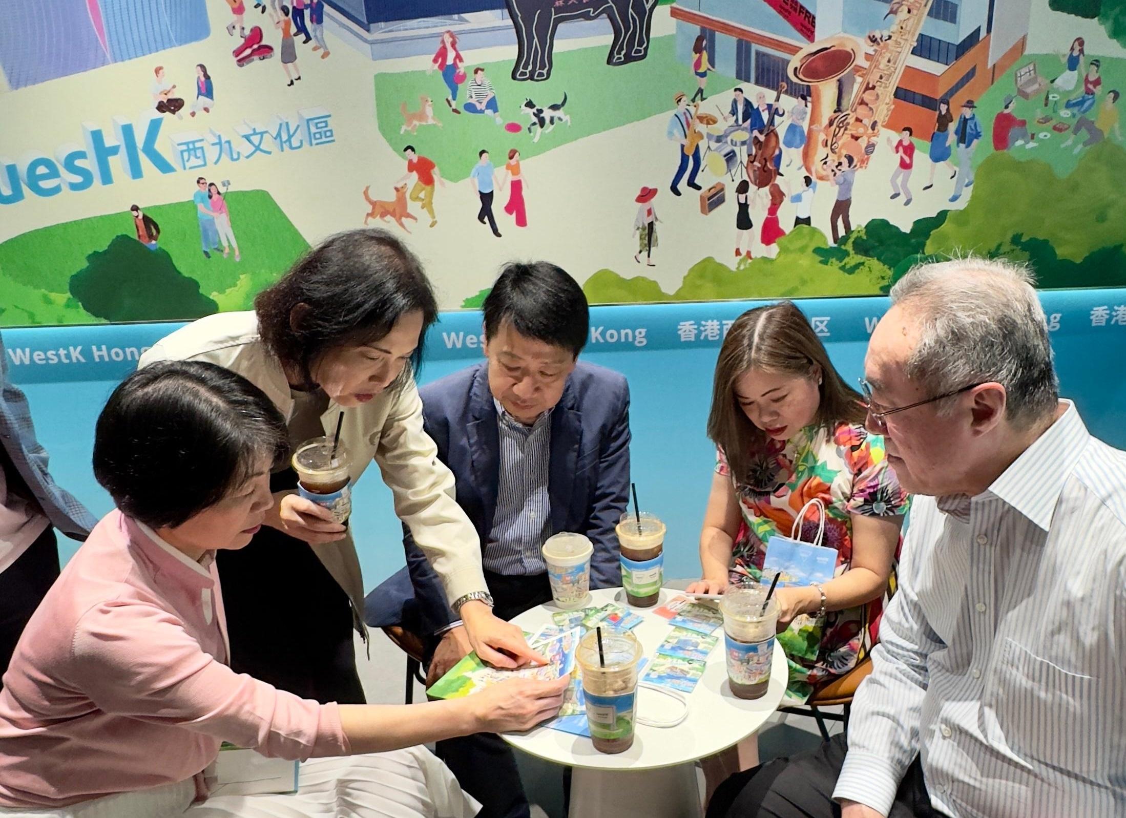 The Secretary for Culture, Sports and Tourism, Miss Rosanna Law, visited the "WestK x MANNER" limited-edition art collaboration themed store jointly rolled out by the West Kowloon Cultural District Authority (WKCDA) and Shanghai's beloved coffee brand MANNER COFFEE in Shanghai today (June 18). Photo shows Miss Law (second right); the Permanent Secretary for Culture, Sports and Tourism, Ms Vivian Sum (first left); the Chairman of the Board of WKCDA, Mr Henry Tang (first right); Member of the Board of WKCDA, Dr Pang Yiu-kai (centre); and the Chief Executive Officer of WKCDA, Mrs Betty Fung (second left), looking into cultural and creative products.