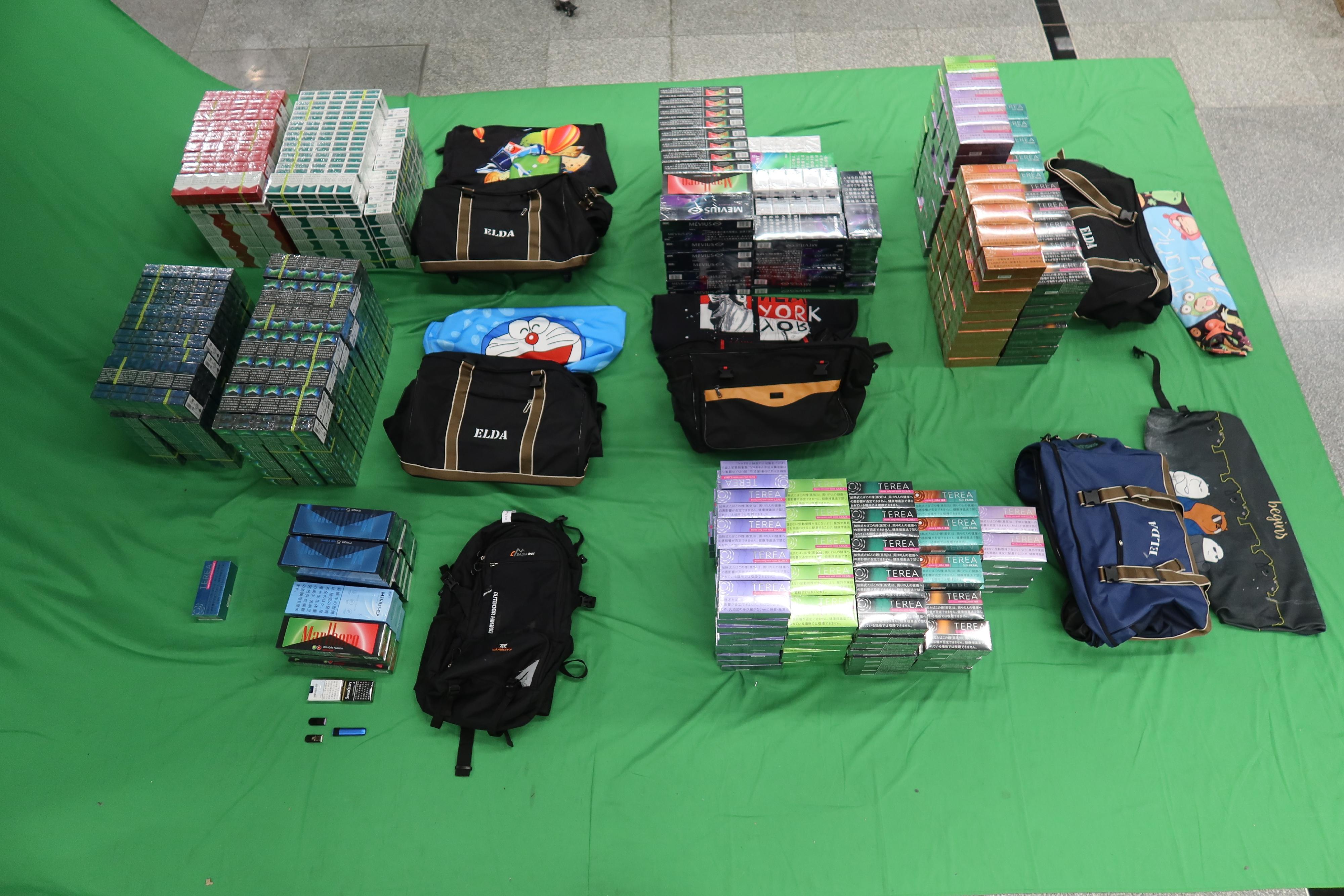 Two incoming 44-year-old male passengers were sentenced to four and six months' imprisonment respectively, with a fine of $1,000, at the West Kowloon Magistrates' Courts today (June 18) for possessing and dealing with duty-not-paid cigarettes and failing to declare them to Customs officers, as well as for importing alternative smoking products, in contravention of the Dutiable Commodities Ordinance and the Import and Export Ordinance. Photo shows the duty-not-paid cigarettes and alternative smoking products seized.

