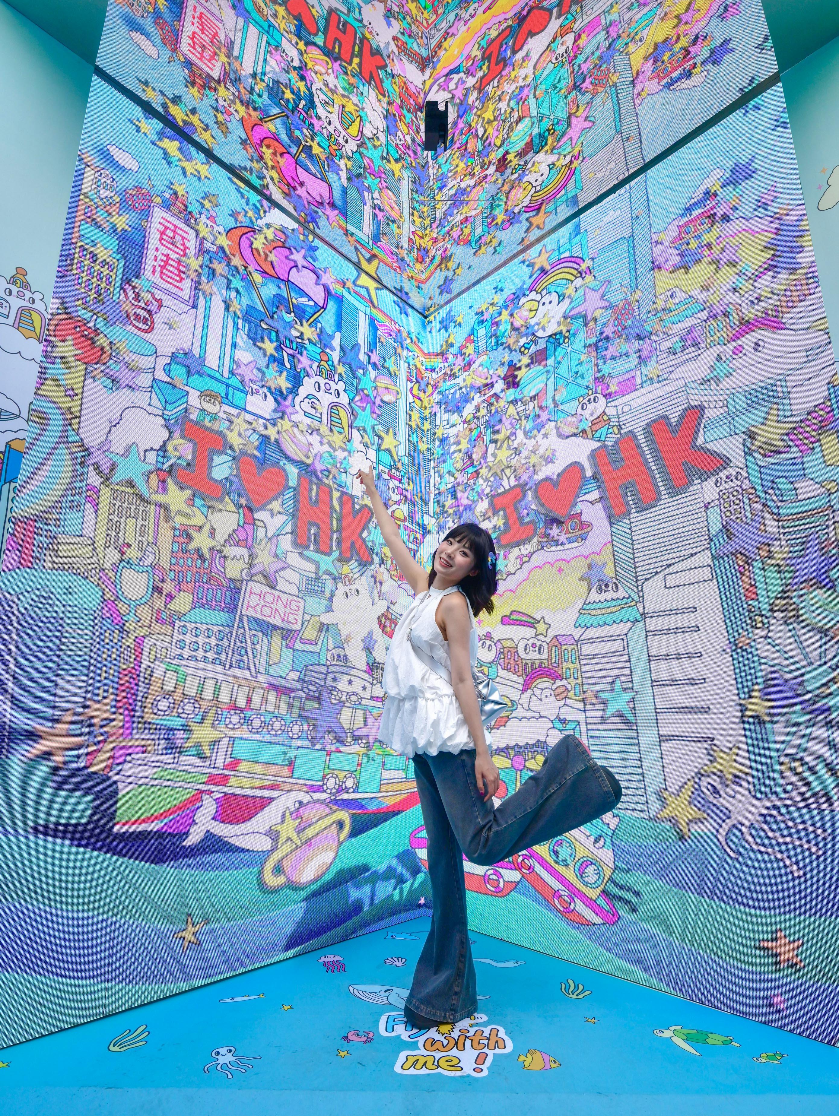 The "Immersive Hong Kong" roving exhibition, which showcases the charm and vibrancy of Hong Kong through interactive art technology, opened in Shanghai today (June 19). The exhibition invites visitors from Shanghai and the Yangtze River Delta to explore the unique opportunities and potential for tourism, education, business and investment in Hong Kong. Photo shows a photo corner featuring the illustration works of Hong Kong artist Messy Desk (Jane Lee) at the exhibition. 