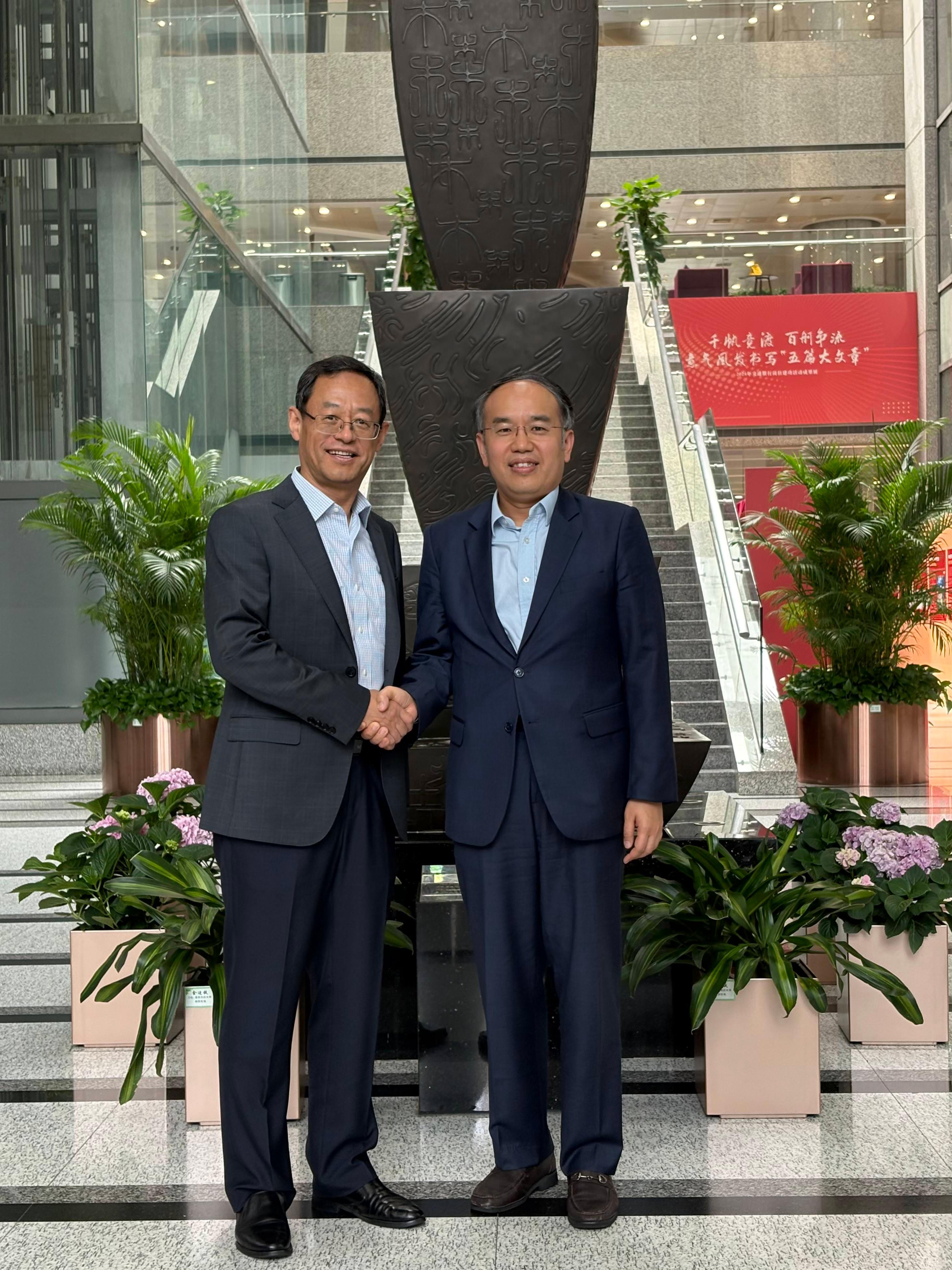 The Secretary for Financial Services and the Treasury, Mr Christopher Hui (right), is pictured with the President of the Bank of Communications, Mr Zhang Baojiang (left), after their meeting in Shanghai today (June 19).
