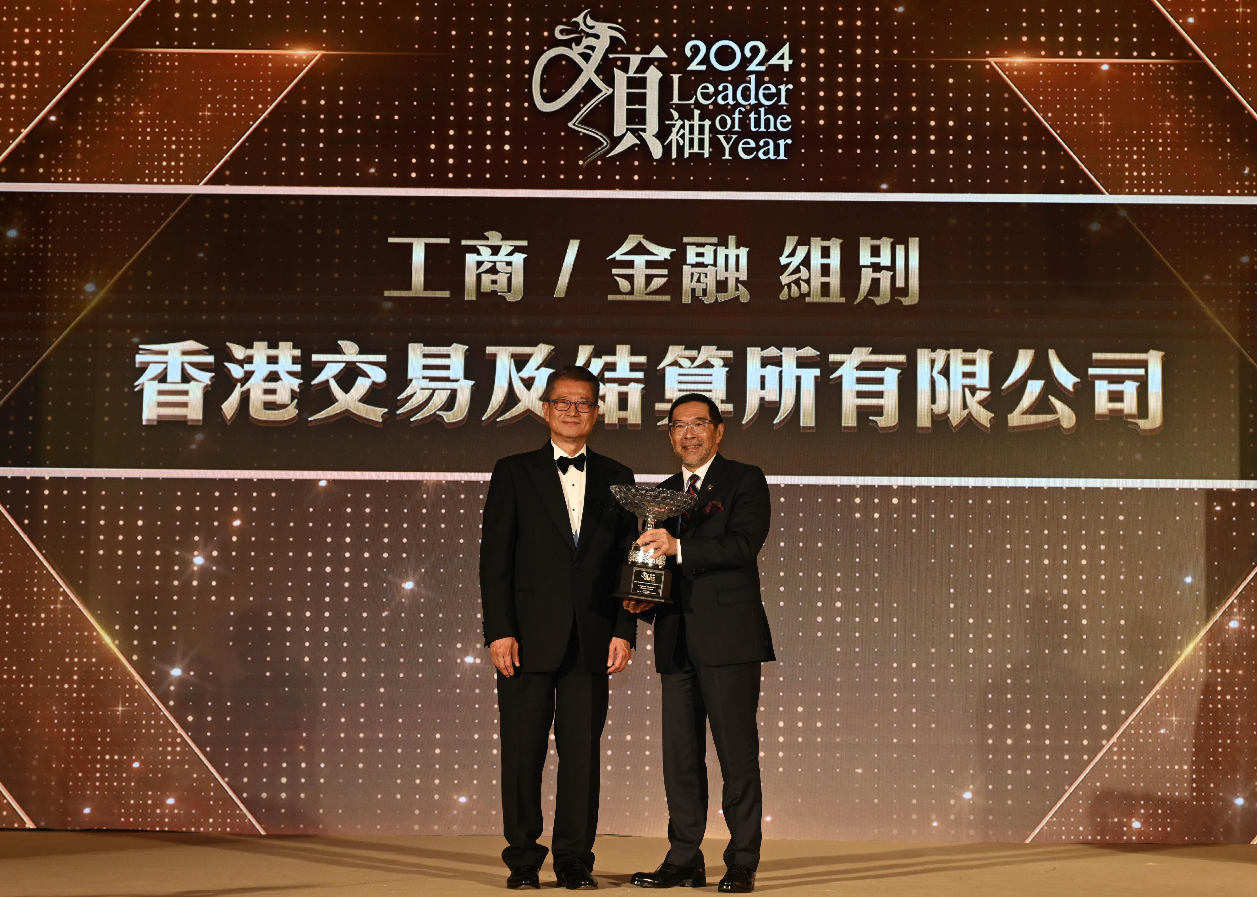 財政司司長陳茂波今日（六月二十日）出席2024年傑出領袖選舉頒獎晚宴。圖示陳茂波（左）頒發獎項予香港交易及結算所有限公司主席唐家成（右）。