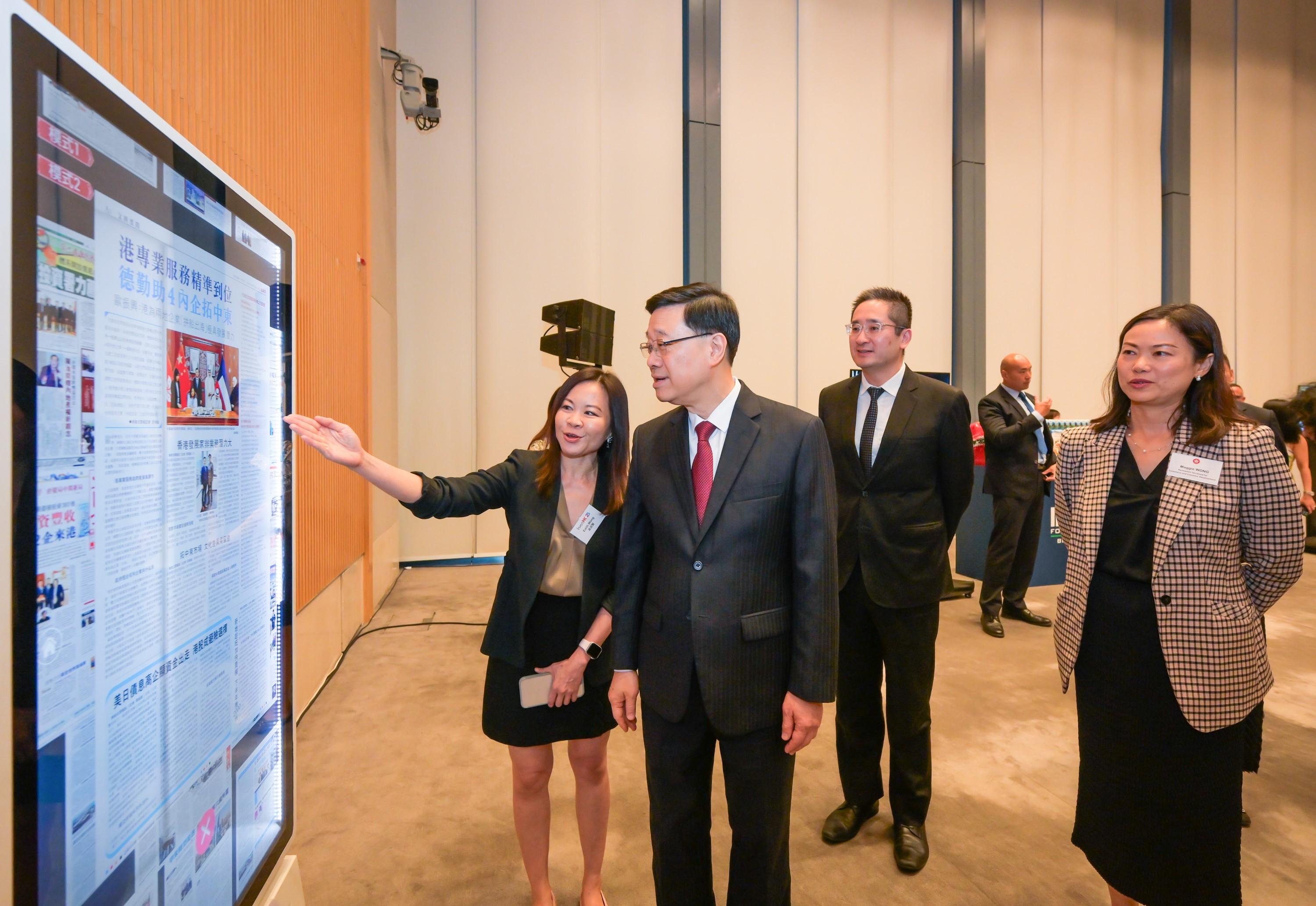 Invest Hong Kong (InvestHK) hosted a reception today (June 24) for new establishments of international and Mainland businesses in Hong Kong to thank businesses for their trust and support in Hong Kong's business environment. A product display area was featured at the reception, showcasing InvestHK clients' innovations and business ideas across sectors such as innovation and technology, consumer products, and tourism and hospitality. Photo shows the Chief Executive, Mr John Lee (second left), visiting Hong Kong Ta Kung Wen Wei Media Group booth, which features a curated archive of InvestHK's media coverage from the past 25 years. The content is presented through an interactive digital photo wall, showcasing InvestHK's initiatives in promoting business and investment in Hong Kong.  

