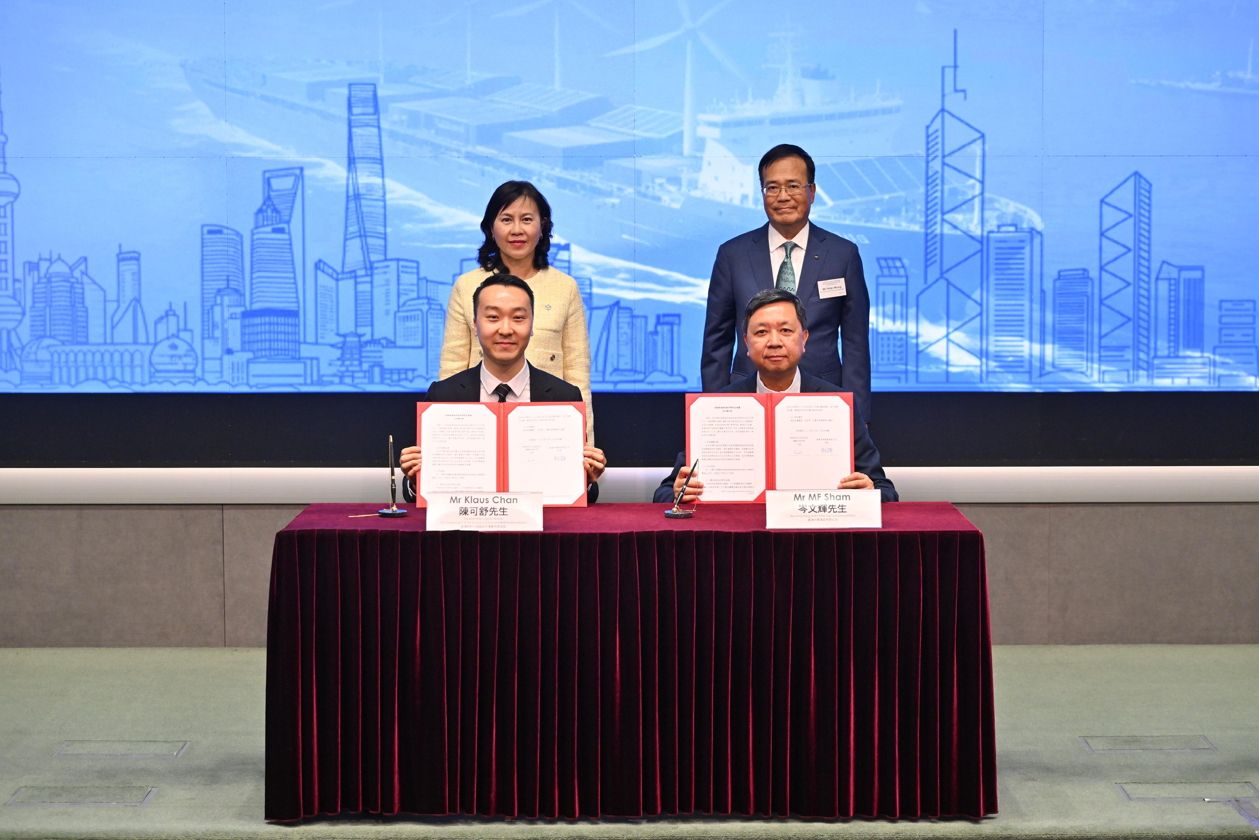 The Mainland-Hong Kong Green Energy Matchmaking Event was held today (June 25) simultaneously in Hong Kong and Shenzhen. Photo shows representatives from the Transport and Logistics Bureau and the Hong Kong and China Gas Company Limited signing a Memorandum of Understanding, witnessed by the Secretary for Transport and Logistics, Ms Mable Chan (back row, left), at the Hong Kong venue.