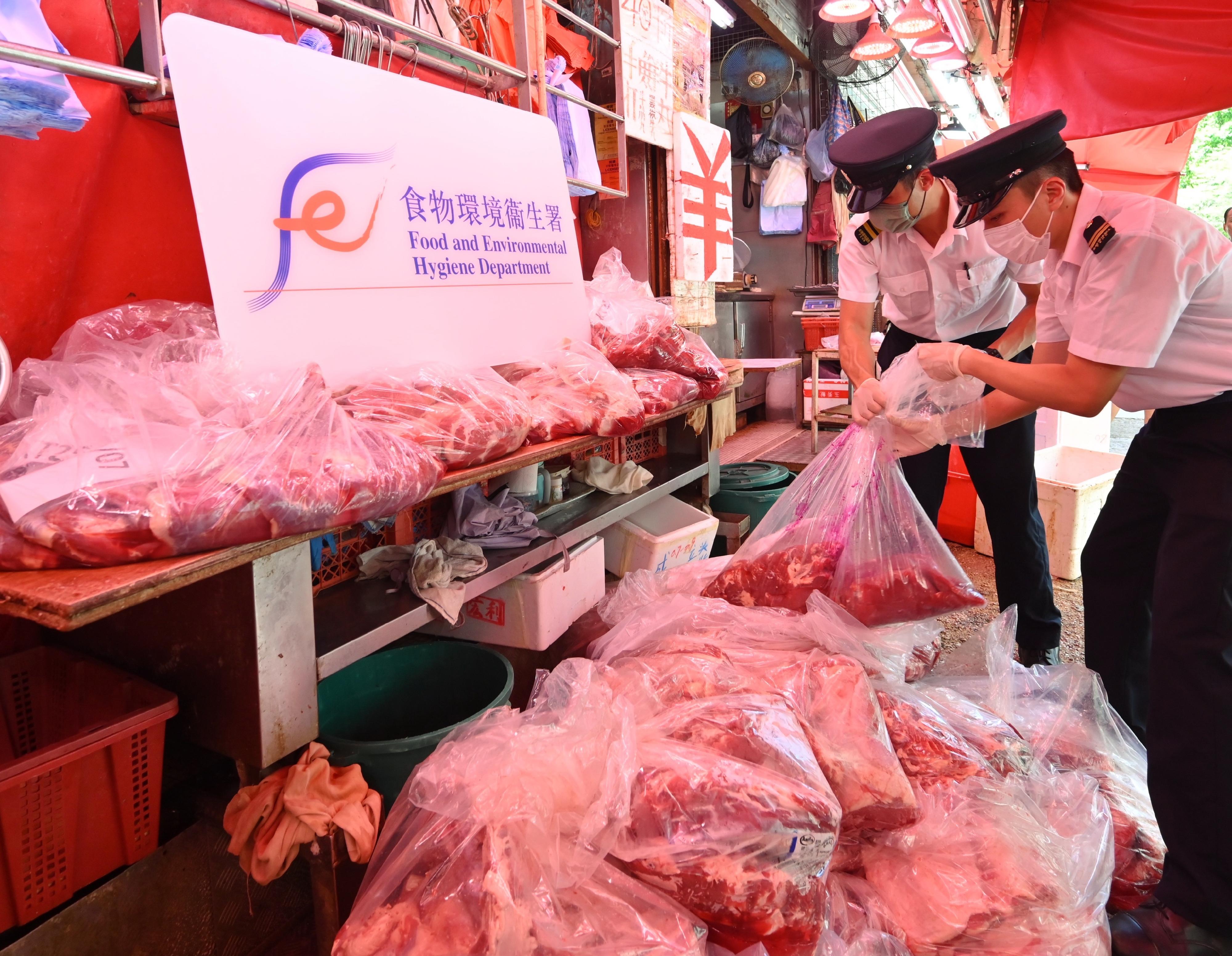 The Food and Environmental Hygiene Department (FEHD) today (June 25) conducted a raid on a licensed fresh provision shop in Kwun Tong District suspected of selling frozen meat as fresh meat. Photo shows FEHD officers sealing some of the meat during the operation for further investigation.
