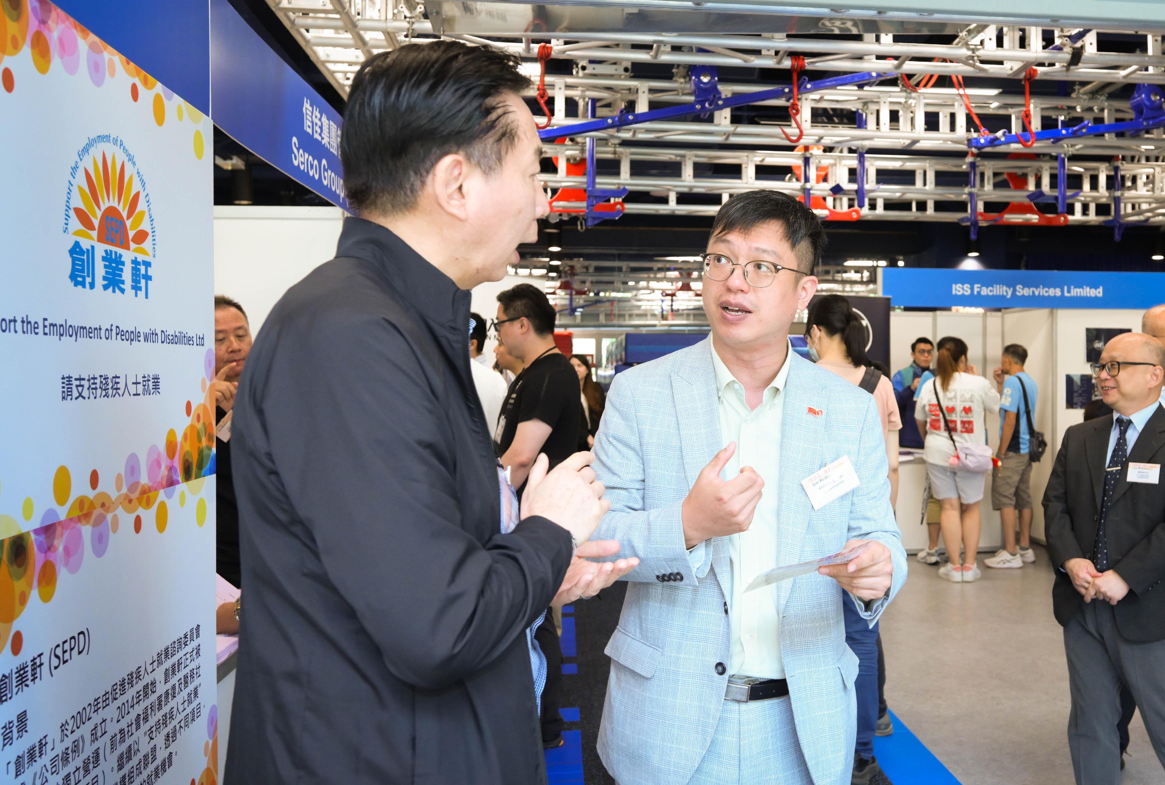 The Under Secretary for Labour and Welfare, Mr Ho Kai-ming, officiated at the appreciation ceremony of the Talent-Wise Inclusive Job Fair today (June 26). Photo shows Mr Ho (right) visiting a recruitment booth and chatting with an employer offering job vacancies.